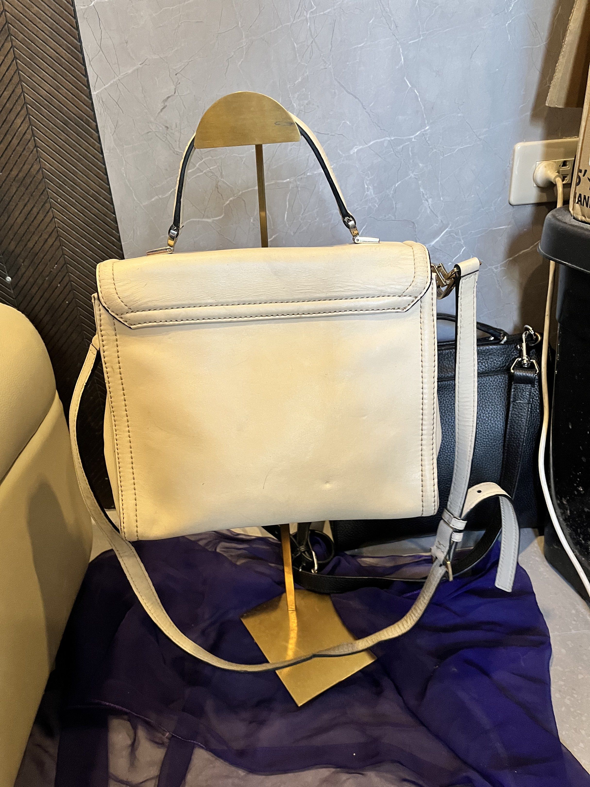 Kate Spade Cream Leather Handbag (Category: Luxury Bags & Wallets) located in Cebu City. Submitted by nbetcuban007trendyfinds (Listing ID 1418451745, Image 3). Description: - Cream-colored Kate Spade handbag - Top handle and detachable shoulder strap - Flap closure with gold-tone metal detail - Cream-colored interior with a small pocket - Rectangular shape, structured design - Metal studs on the bottom.