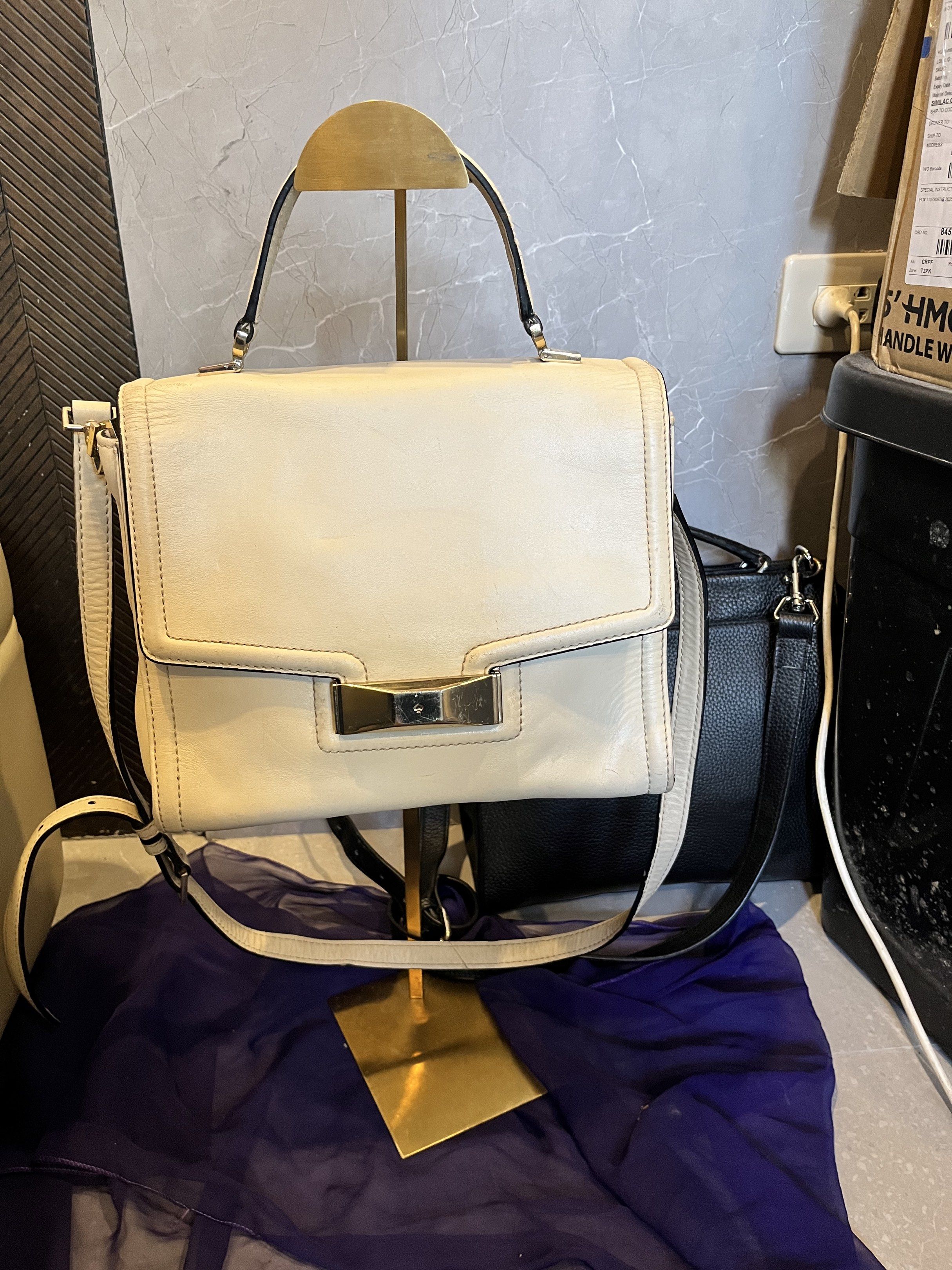 Kate Spade Cream Leather Handbag (Category: Luxury Bags & Wallets) located in Cebu City. Submitted by nbetcuban007trendyfinds (Listing ID 1418451745, Image 2). Description: - Cream-colored Kate Spade handbag - Top handle and detachable shoulder strap - Flap closure with gold-tone metal detail - Cream-colored interior with a small pocket - Rectangular shape, structured design - Metal studs on the bottom.