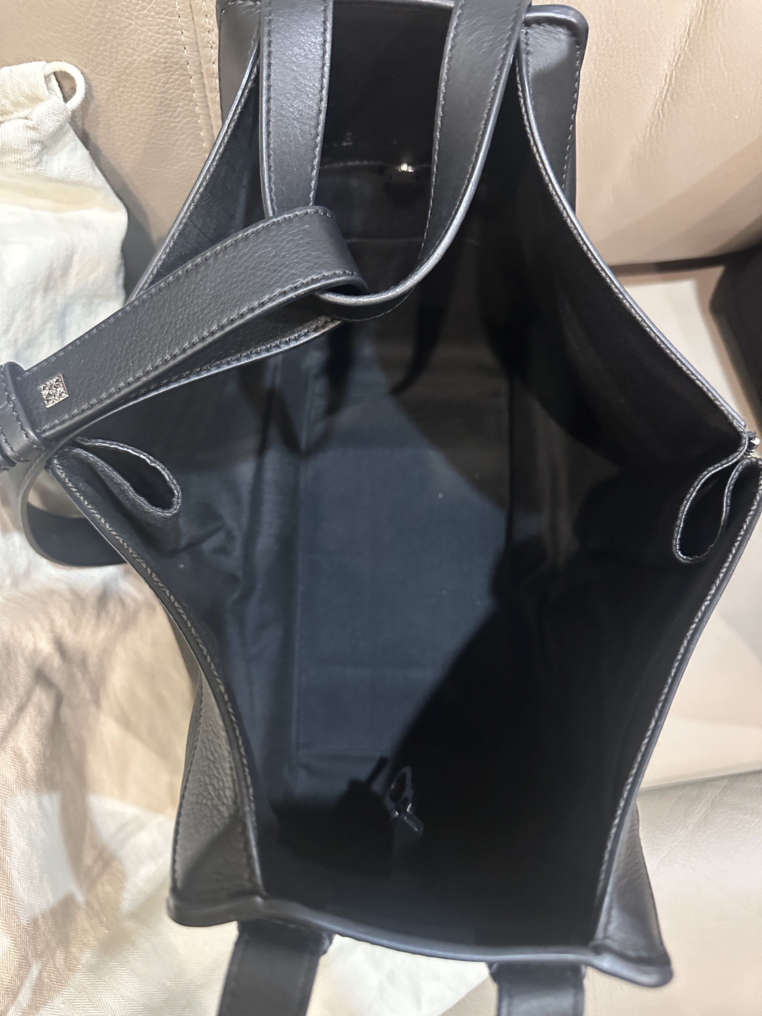 Loewe Hammock Small Bag Black (Category: Luxury Bags & Wallets) located in Koronadal. Submitted by andreamichelle75 (Listing ID 1418489806, Image 3). Description: - Authentic Loewe Hammock Small Bag - Color: Black - Size: Small - Features: - Top handle or Cross Body (adjustable strap) - Detachable shoulder strap - Includes: Dust bag and free inner felt organizer - Interior: Black fabric - Exterior: Loewe logo embossed on the front.