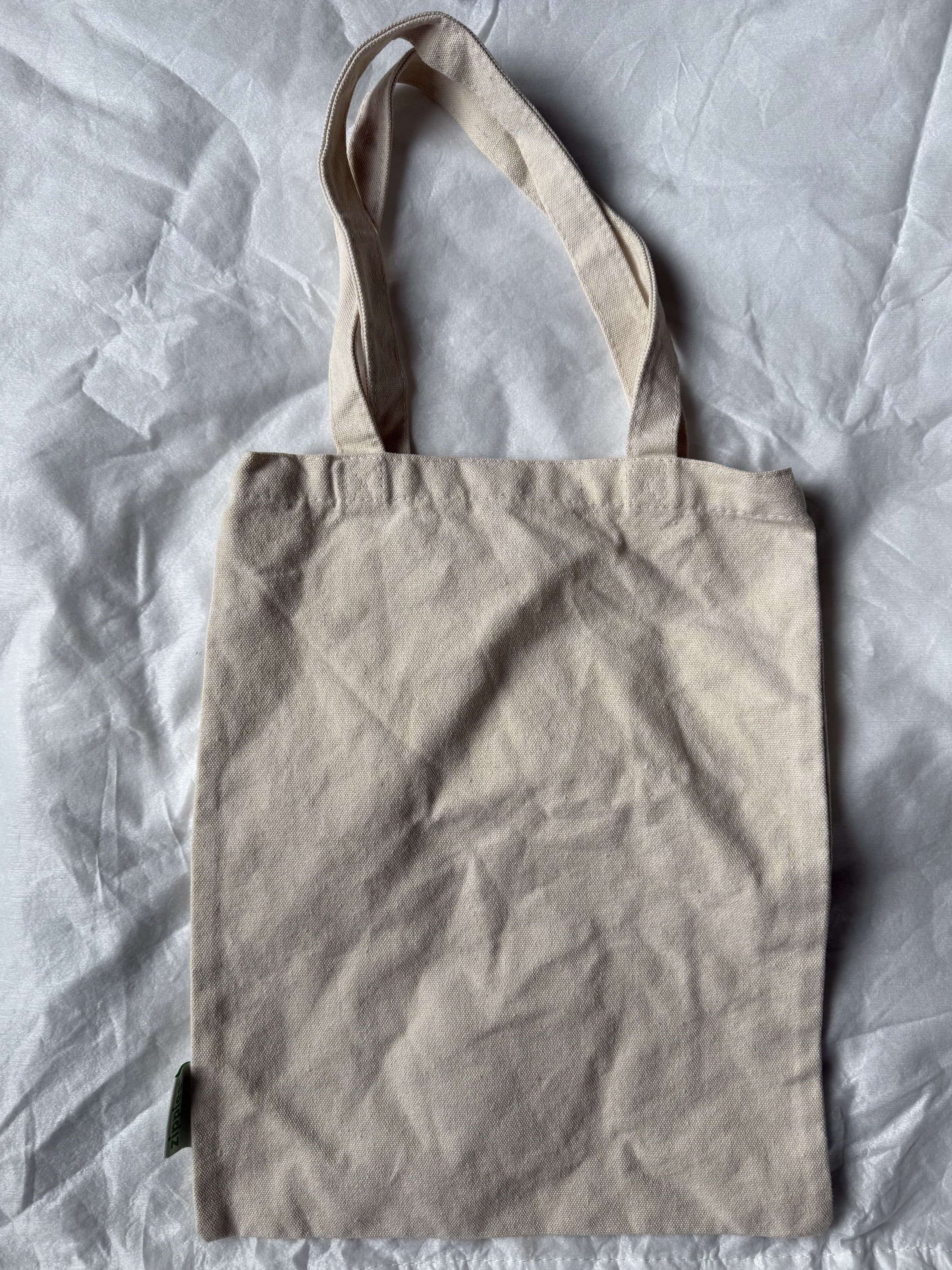 Love For All Tote Bag (Category: Tote Bags) located in Manila. Submitted by stuffcartph (Listing ID 1418426842, Image 2). Description: - Beige tote bag - Features "LOVE FOR ALL" print - Two handles for carrying - Includes a small side tag - Plain back - Ideal for everyday use.
