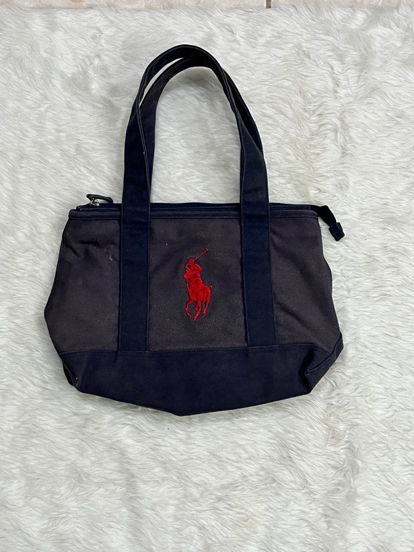 Polo Ralph Lauren Tote Bag (Category: Luxury Bags & Wallets) located in Iloilo. Submitted by cloud.thrifts (Listing ID 1418512506, Image 1). Description: - Navy blue Polo Ralph Lauren tote bag - Red embroidered logo - Zippered main compartment - Interior zippered pocket - Two handles for carrying - Authentic Polo Ralph Lauren label inside.