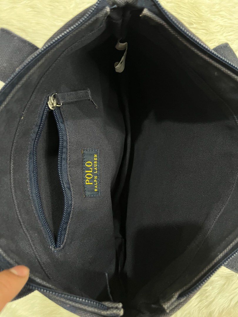 Polo Ralph Lauren Tote Bag (Category: Luxury Bags & Wallets) located in Iloilo. Submitted by cloud.thrifts (Listing ID 1418512506, Image 2). Description: - Navy blue Polo Ralph Lauren tote bag - Red embroidered logo - Zippered main compartment - Interior zippered pocket - Two handles for carrying - Authentic Polo Ralph Lauren label inside.