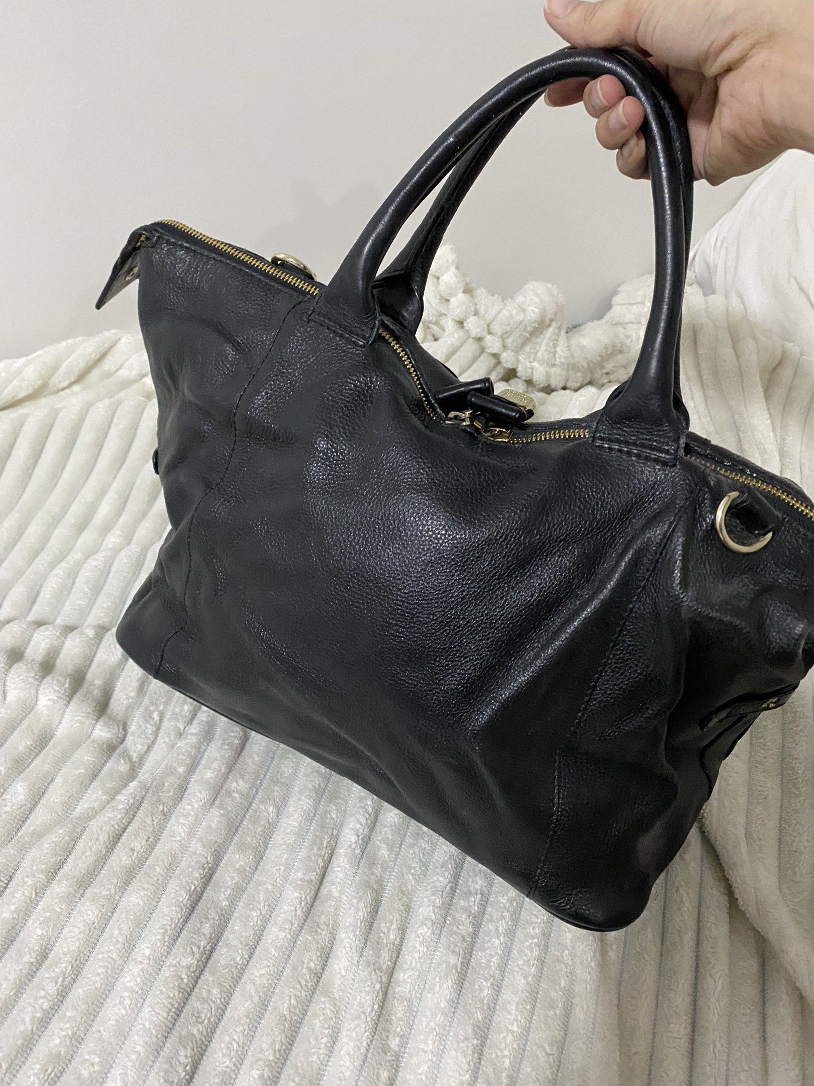 Authentic See by Chloé Black Leather Handbag (Category: Luxury Bags & Wallets) located in Santa Rosa. Submitted by sassycollection. (Listing ID 1418413681, Image 3). Description: - See by Chloé handbag - Black leather - Gold-tone hardware - Includes double handles - Detachable shoulder strap - Interior lined with grey fabric - Features brand tag - Made in India.