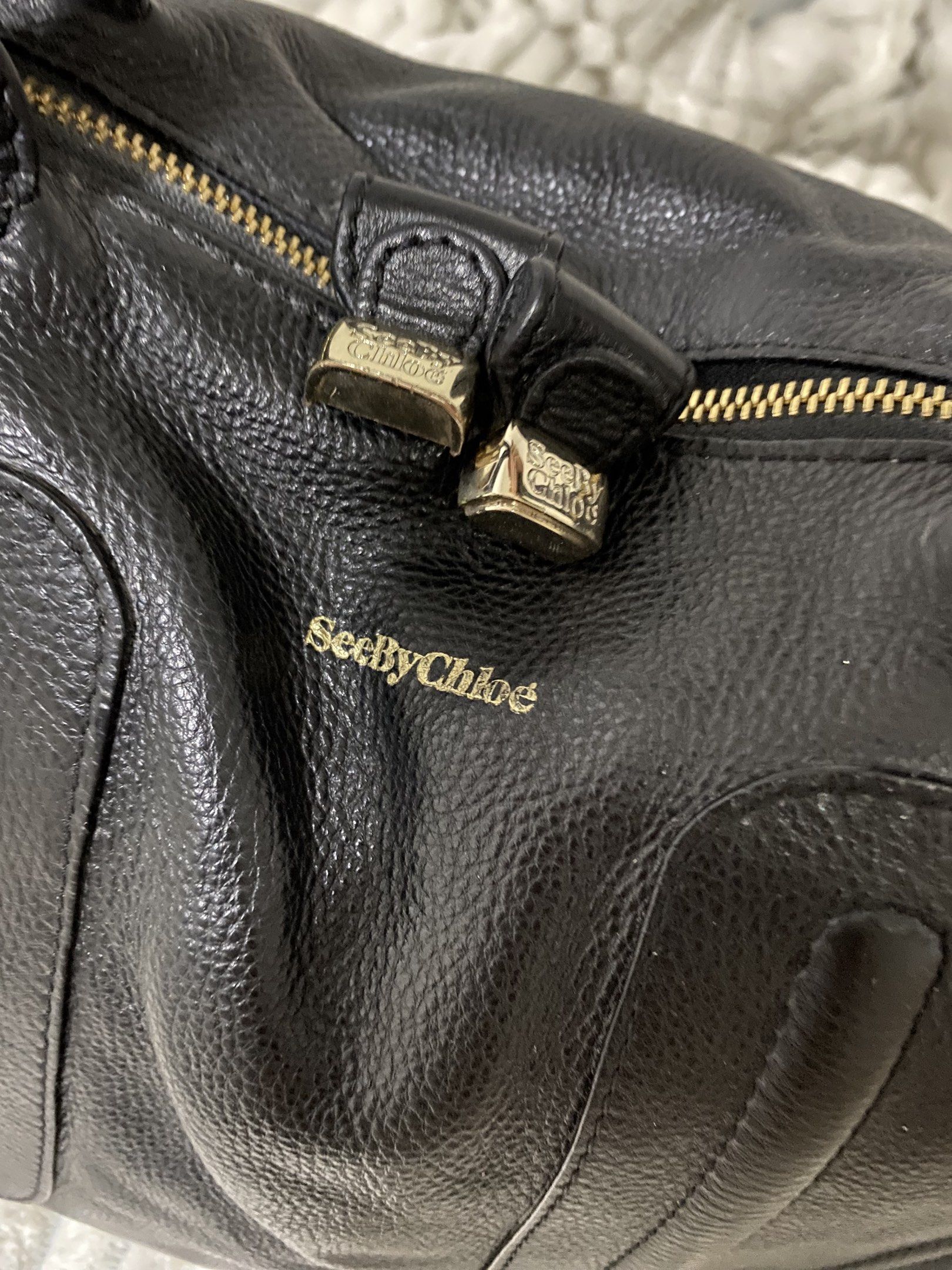 Authentic See by Chloé Black Leather Handbag (Category: Luxury Bags & Wallets) located in Santa Rosa. Submitted by sassycollection. (Listing ID 1418413681, Image 2). Description: - See by Chloé handbag - Black leather - Gold-tone hardware - Includes double handles - Detachable shoulder strap - Interior lined with grey fabric - Features brand tag - Made in India.