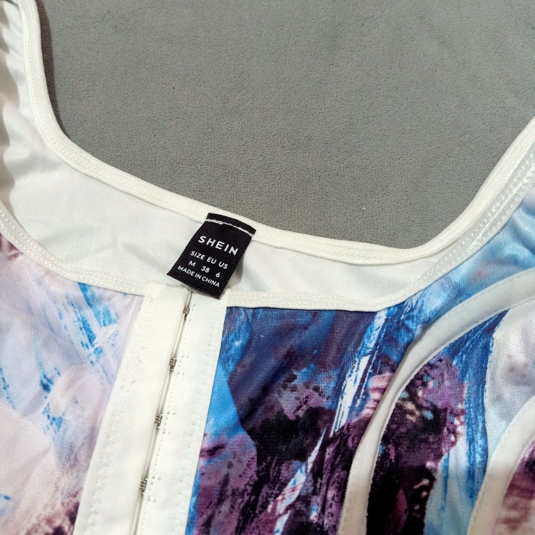 SHEIN Corset-Style Crop Top (Category: Sleeveless) located in San Jose. Submitted by gemhavenxx (Listing ID 1418594696, Image 3). Description: -Abstract Painterly Print with a modern, edgy silhouette -Features white structural piping (boning channels) on the front to create a defined corset shape. -Square neckline with wide non-adjustable shoulder straps. -Size on Tag: Medium (M) EU: 38 US: 6 -With pouch..