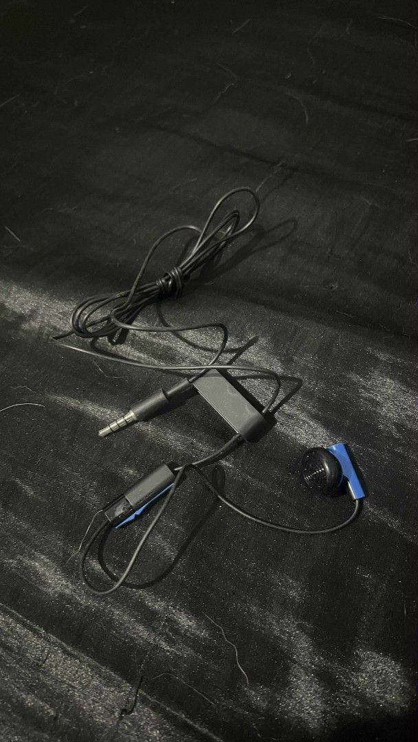 Sony Original Wired Mono Headset Earphone for PS4/PS5 (Category: Earphones) located in Quezon City. Submitted by seeeen (Listing ID 1418559048, Image 1). Description: Unused. Black wired earphones with a built-in microphone. Includes a blue clip for securing the wire. Features a 3.5mm audio jack. .