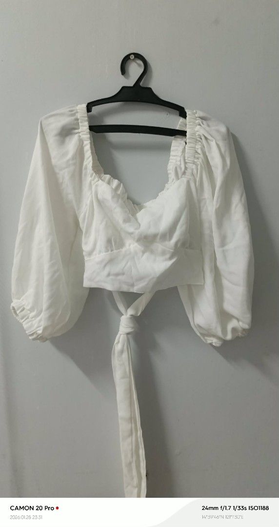 White Puff Sleeve Crop Top (Category: Blouses) located in Quezon City. Submitted by sheila0721 (Listing ID 1418464488, Image 2). Description: - White crop top - Puff sleeves - Tie-back detail - Square neckline - Gathered bodice - Long sleeves with cuffs - Lightweight fabric - Suitable for casual and semi-formal occasions.