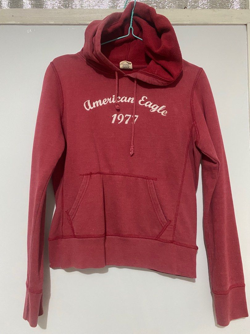 American Eagle 1977 Hoodie (Category: Coats, Jackets and Outerwear) located in San Pedro. Submitted by jen.declutter (Listing ID 1413283062, Image 1). Description: - American Eagle hoodie - Red color - "American Eagle 1977" logo on the front - Hood with drawstring - Front pocket - Ribbed cuffs - Soft, comfortable material.