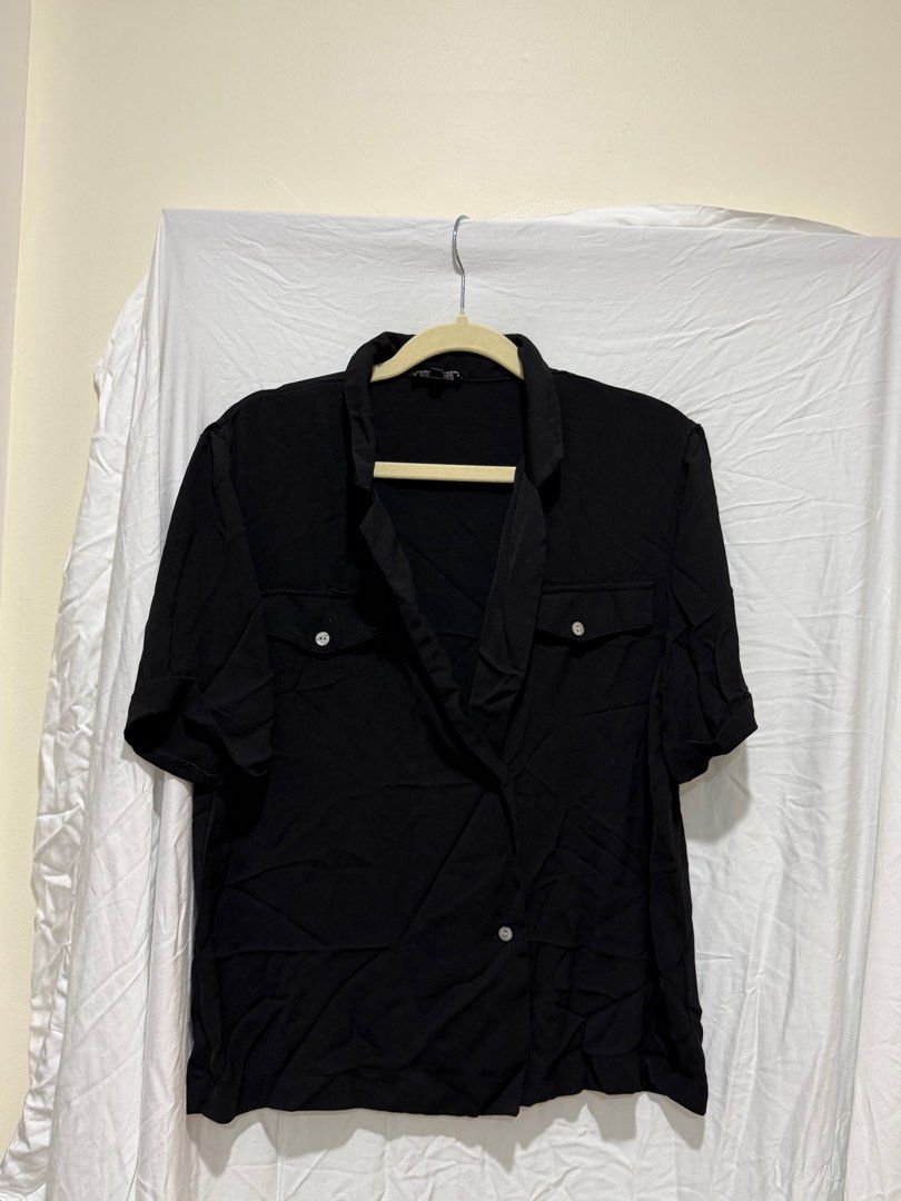 Black Short Sleeve Shirt (Category: Shirts) located in Paranaque City. Submitted by vjau_ (Listing ID 1413393887, Image 1). Description: - minor damage in the pocket area - Black short sleeve shirt - Two chest pockets - Button closure - Collared neckline - Lightweight fabric - Relaxed fit - Ideal for casual wear.