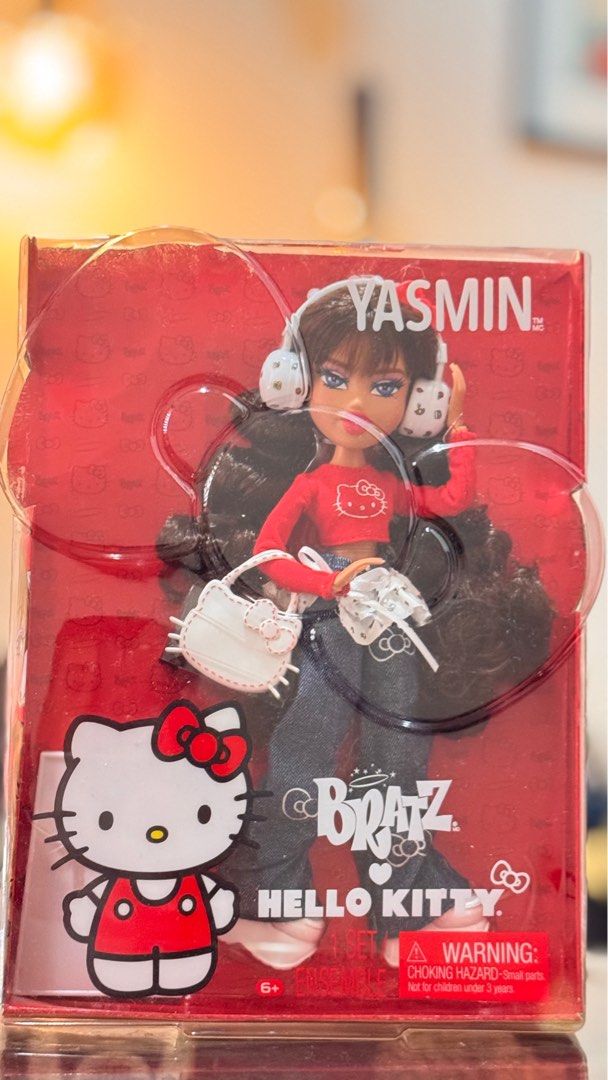 Bratz Hello Kitty Yasmin Doll (Available) (Category: Kids Toys) located in Mandaluyong City. Submitted by sellingdollz (Listing ID 1413295505, Image 2). Description: - Bratz Yasmin doll in collaboration with Kitty. - Features Yasmin wearing a red Kitty shirt, jeans, and headphones. - Includes a white Kitty handbag and other accessories. - Comes with original red packaging with Kitty branding. - Part of a complete set..