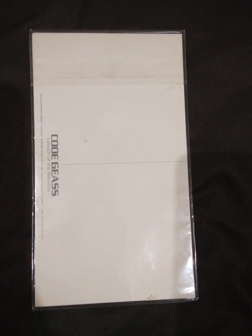 Code Geass Postcard Set (Category: Raw Singles) located in Santa Rosa. Submitted by animemerchcollection (Listing ID 1413330460, Image 3). Description: Set of Code Geass postcards. The set includes multiple postcards featuring different characters and scenes from the anime series. The postcards are in a sealed plastic packaging. The back of the packaging shows the Code Geass logo..