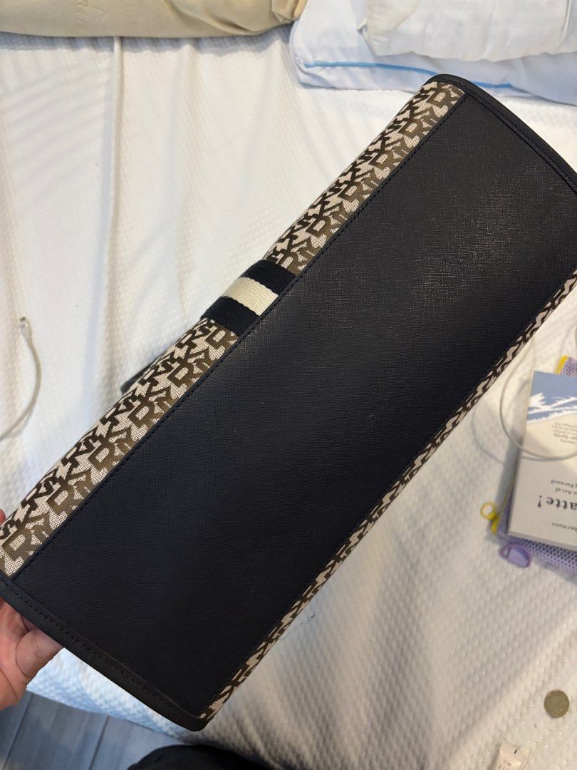 DKNY Tote Bag (Category: Luxury Bags & Wallets) located in Manila. Submitted by coolwinddd (Listing ID 1413384664, Image 3). Description: - DKNY tote bag - Monogram pattern - Black handles and trim - Vertical stripe detail - DKNY logo lining - Multiple compartments - Magnetic snap closure.