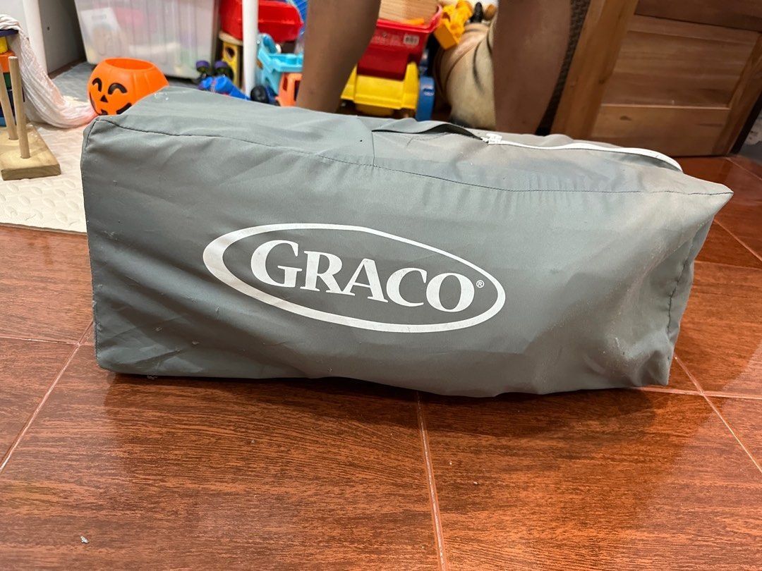Graco Pack 'n Play Simple Solutions Playard (Category: Cots & Cribs) located in Manila. Submitted by theeditmarket (Listing ID 1413242319, Image 2). Description: - Graco Pack 'n Play Simple Solutions Playard - Features a removable full-size bassinet - Compact fold with automatically folding feet and wheels - Easy to store and travel-friendly - Includes a carrying bag - Stylish gray design with a patterned interior.