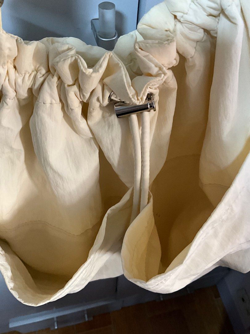 GU Cream-colored Drawstring Shoulder Bag (Category: Shoulder Bags) located in San Pedro. Submitted by dottable (Listing ID 1413434183, Image 2). Description: - NOTE: Small ink stains in one of the interior pockets but won’t be seen from outside - Cream-colored shoulder bag - Drawstring closure - Adjustable wide strap - Exterior pockets - Interior snap closure - Lightweight fabric (nylon) - Suitable for everyday use.