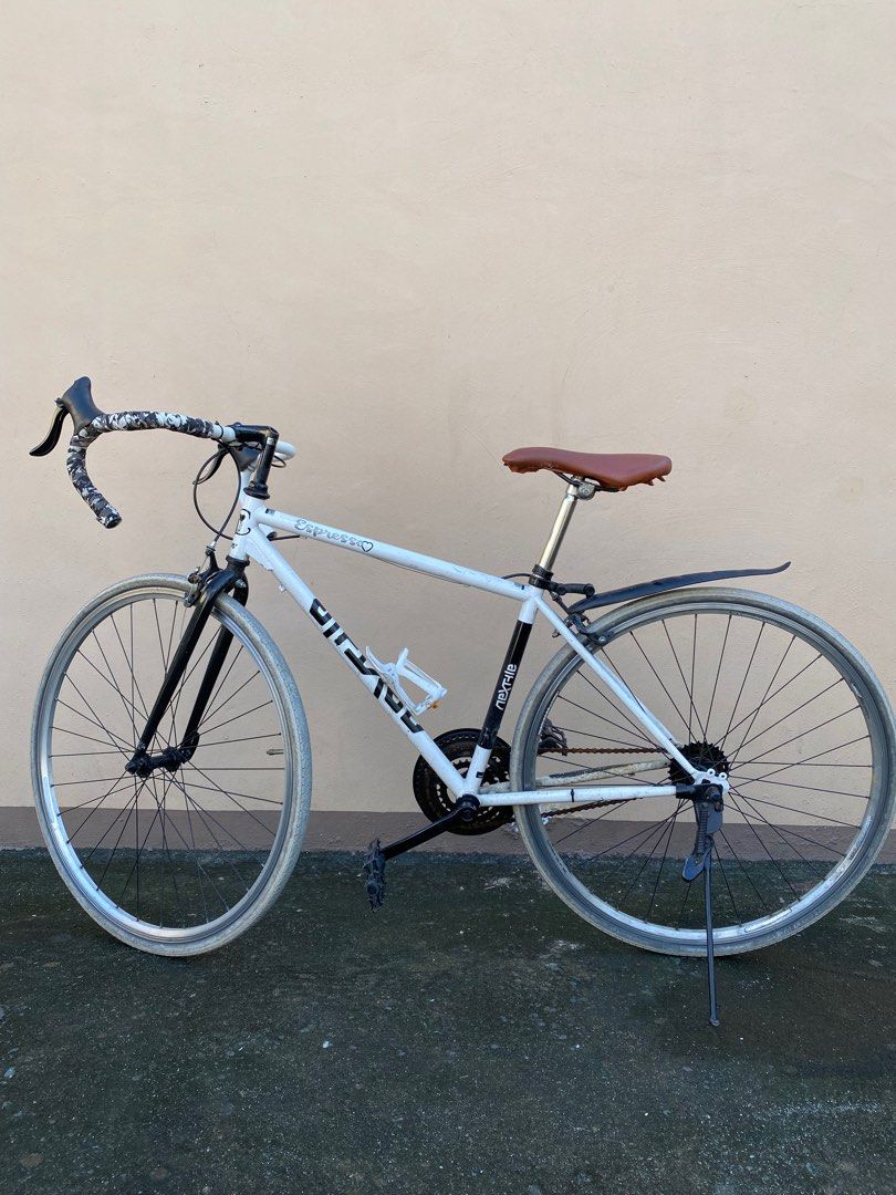 Japanese Road Bike (Category: Bicycles) located in Manila. Submitted by simple_ideas (Listing ID 1413301582, Image 1). Description: - White Nexfile Junior road bike, converted to single speed pero nandun pa rin component. Hindi na inayos at nalinis may bagong roadbike na. As is were is condition. - Drop handlebars - Brown saddle - Rear fender - Black components (fork, crankset, pedals) - 7-speed cassette - Rim brakes - White tires - Includes wate
