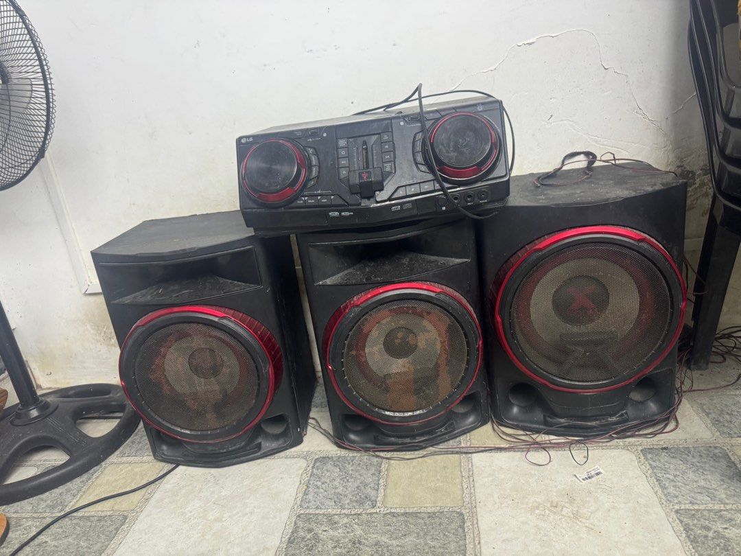 LG Speaker System (Category: Soundbars, Speakers & Amplifiers) located in Malolos. Submitted by jasminever02851 (Listing ID 1413373687, Image 1). Description: - LG speaker system - Includes three speakers and a central control unit - Features red accents around the woofers - Comes with all necessary cables - System is functional and ready to use - 1 speaker not working but can be repaired.