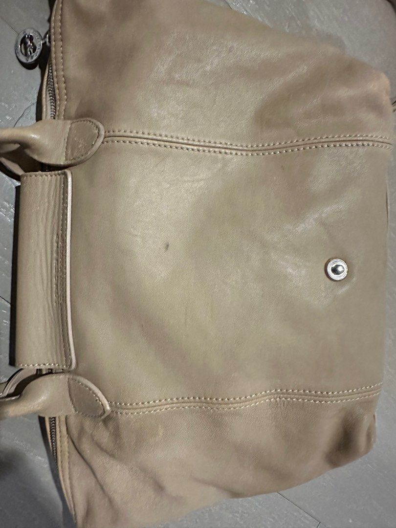 Longchamp Le Pliage Cuir Handbag (Category: Luxury Bags & Wallets) located in Makati City. Submitted by spiffph (Listing ID 1407669507, Image 3). Description: - Longchamp Le Pliage Cuir handbag - Beige leather exterior - Top handle and detachable shoulder strap - Flap closure with snap button - Embossed Longchamp logo - Small.