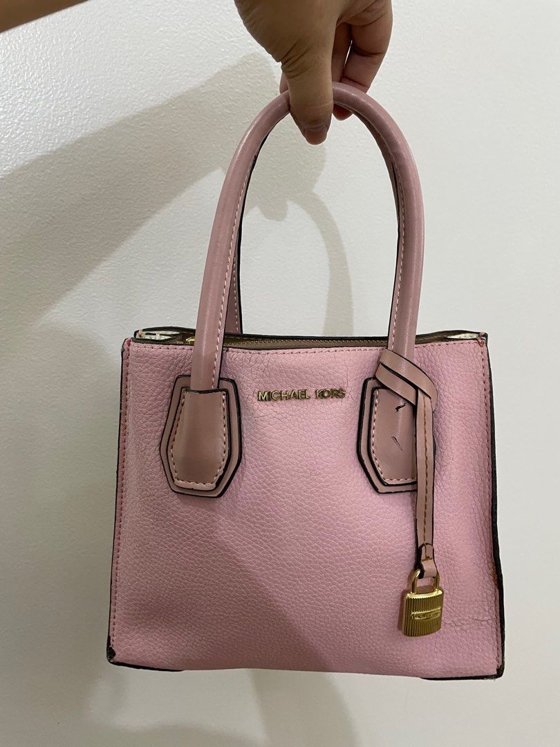 Michael Kors Pink Satchel Handbag (Category: Luxury Bags & Wallets) located in Taguig. Submitted by joyce.yoingco (Listing ID 1413347934, Image 2). Description: - Authentic Michael Kors satchel - Color: Pink - Features top handles - Gold-tone padlock and zipper closure - Interior lined with beige fabric - Includes Michael Kors label - Structured shape with textured finish - Protective feet at the bottom.