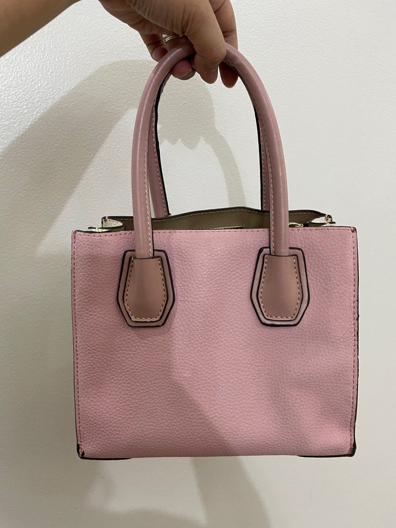 Michael Kors Pink Satchel Handbag (Category: Luxury Bags & Wallets) located in Taguig. Submitted by joyce.yoingco (Listing ID 1413347934, Image 3). Description: - Authentic Michael Kors satchel - Color: Pink - Features top handles - Gold-tone padlock and zipper closure - Interior lined with beige fabric - Includes Michael Kors label - Structured shape with textured finish - Protective feet at the bottom.