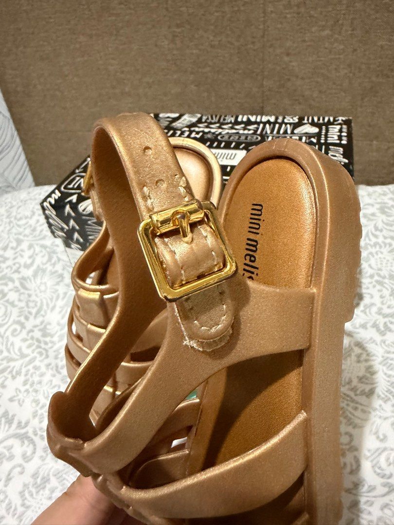 Mini Melissa Flox Shine BB Gold Sandals (Category: Babies & Kids Fashion) located in Makati City. Submitted by rhen00 (Listing ID 1413246671, Image 2). Description: - Mini Melissa Flox Shine BB sandals - Color: Gold - Size: USA 9 - Features: Buckle closure, woven design - Includes original box - Made in Brazil.
