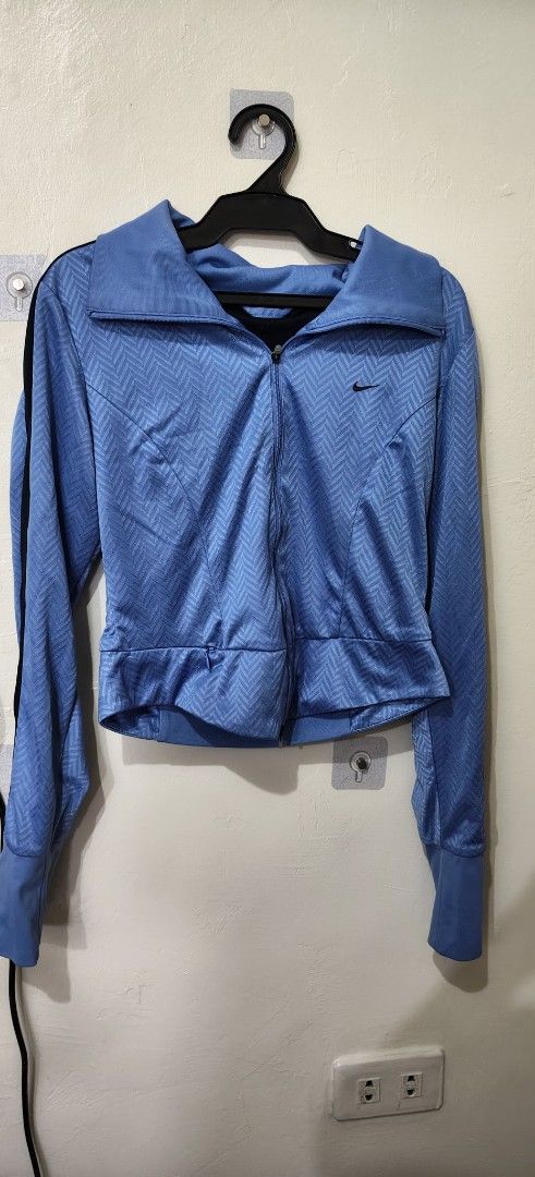 Nike Blue Zip-Up Jacket (Category: Coats, Jackets and Outerwear) located in Quezon City. Submitted by jonree (Listing ID 1413329261, Image 2). Description: - Blue Nike zip-up jacket - Textured pattern - Small Nike logo on chest - Full-length zipper - Collar - Black stripes on sleeves - Fitted style - Dark blue lining.