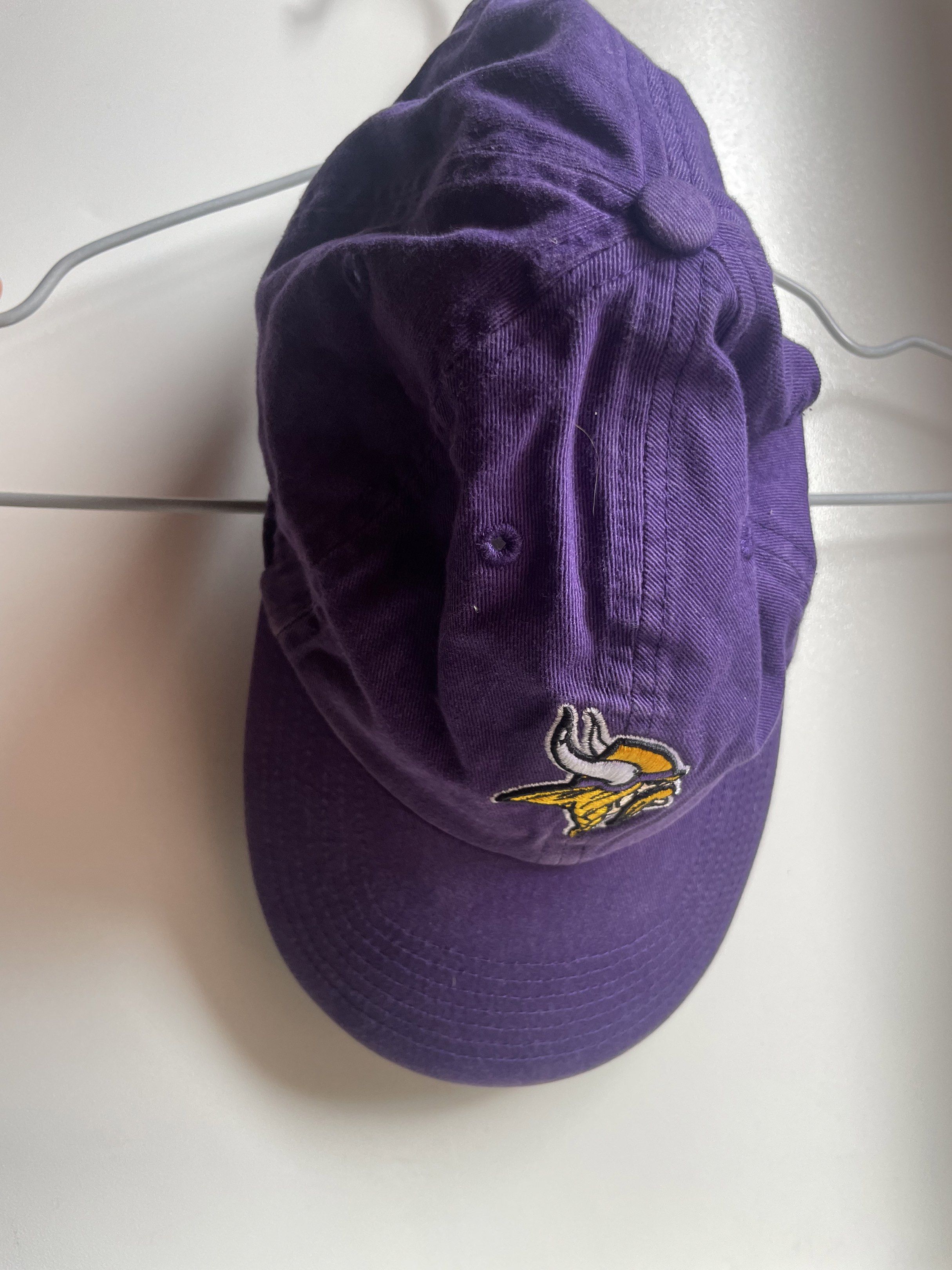 47 Brand NFL Minnesota Vikings Cap (Category: Caps & Hats) located in Manila. Submitted by chenpots (Listing ID 1418640856, Image 2). Description: Cap features the Minnesota Vikings logo on the front. It is a purple cap with an adjustable strap at the back. The brand is 47 Brand. The cap has an NFL sticker inside. The cap has a curved brim and a structured crown. The cap has a 47 Brand logo on the side..