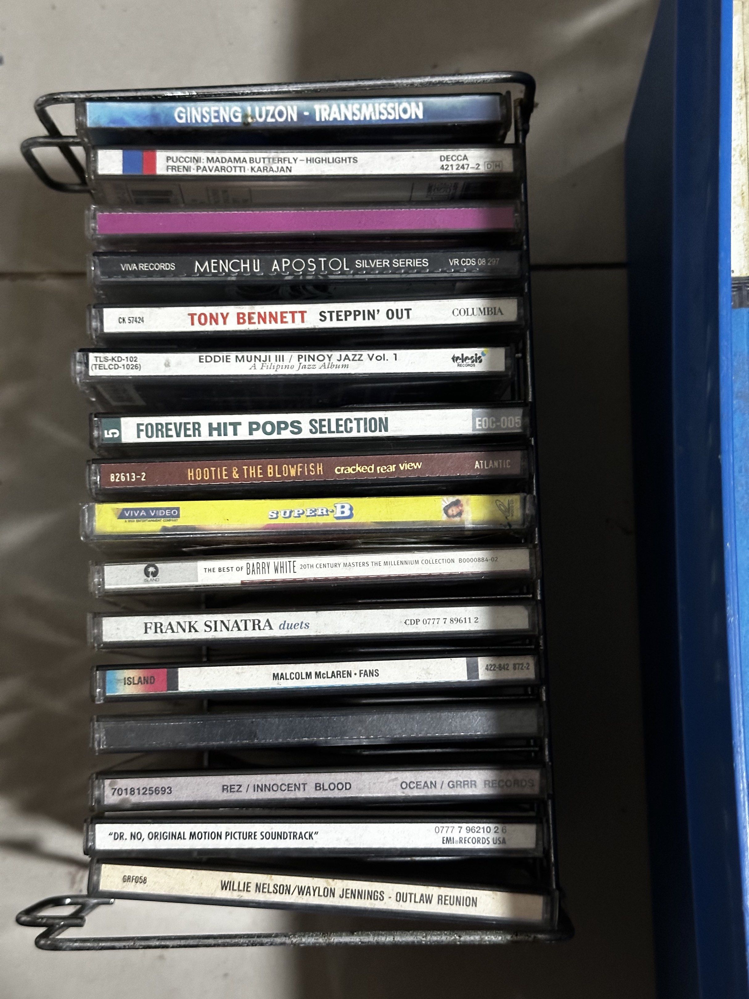 Assorted Music CDs and Cassette Tapes (Category: CDs & DVDs) located in Makati City. Submitted by mjmjmi (Listing ID 1418666997, Image 1). Description: - Music CD and cassette tape collection - Featuring artists like Red Hot Chili Peppers, Barbra Streisand, and Frank Sinatra - Diverse selection of music genres - Some tapes stored in a rack and blue container - Includes various cassette tapes.