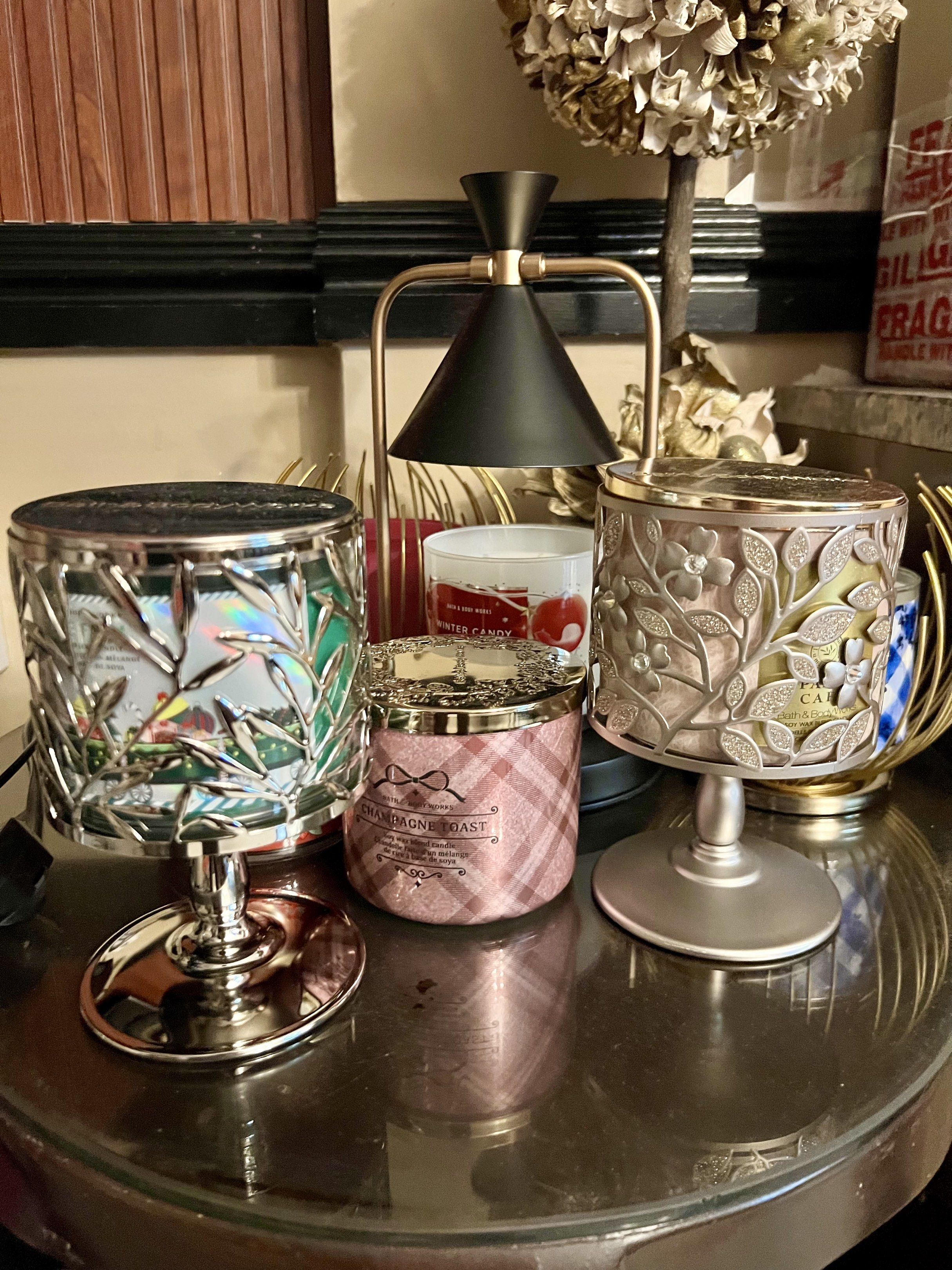 Bath & Body Works Candle Holder (Category: Home Fragrance) located in Paranaque City. Submitted by sctmpque (Listing ID 1418704647, Image 3). Description: - Bath & Body Works candle holder - Decorative silver design with leaf and floral patterns - Designed for standard three-wick candles - Sturdy base and removable lid - Adds a touch of elegance to your space.