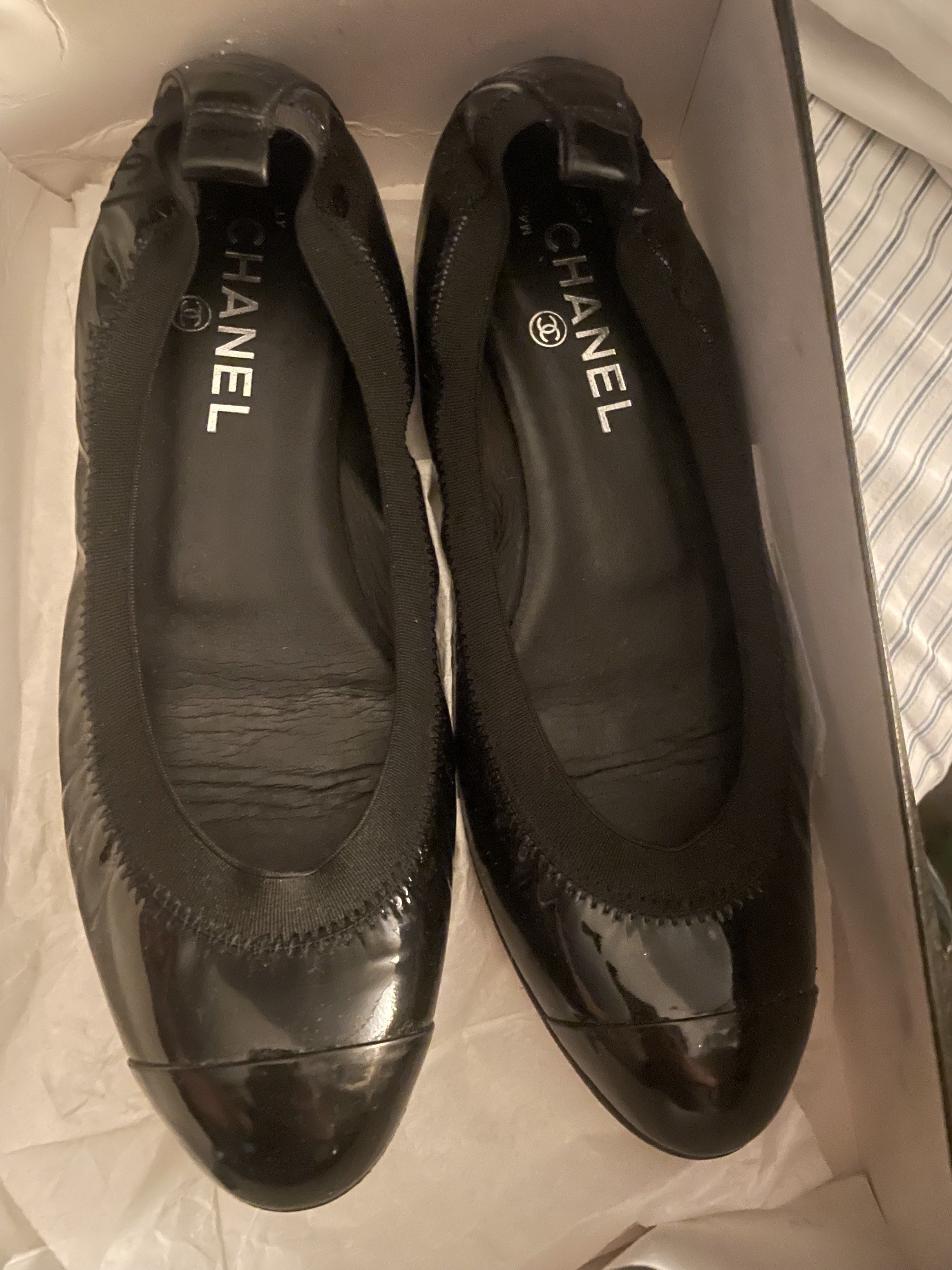 Chanel Black Patent Leather Flats 38.5 (Category: Flats & Sandals) located in Makati City. Submitted by forbesclosetsale (Listing ID 1418528501, Image 2). Description: - Chanel black patent leather flats - Features the Chanel logo - Comes with original box - Rounded toe design - Elasticized trim for comfort - Versatile and classic - A little sticky No Meet Up.