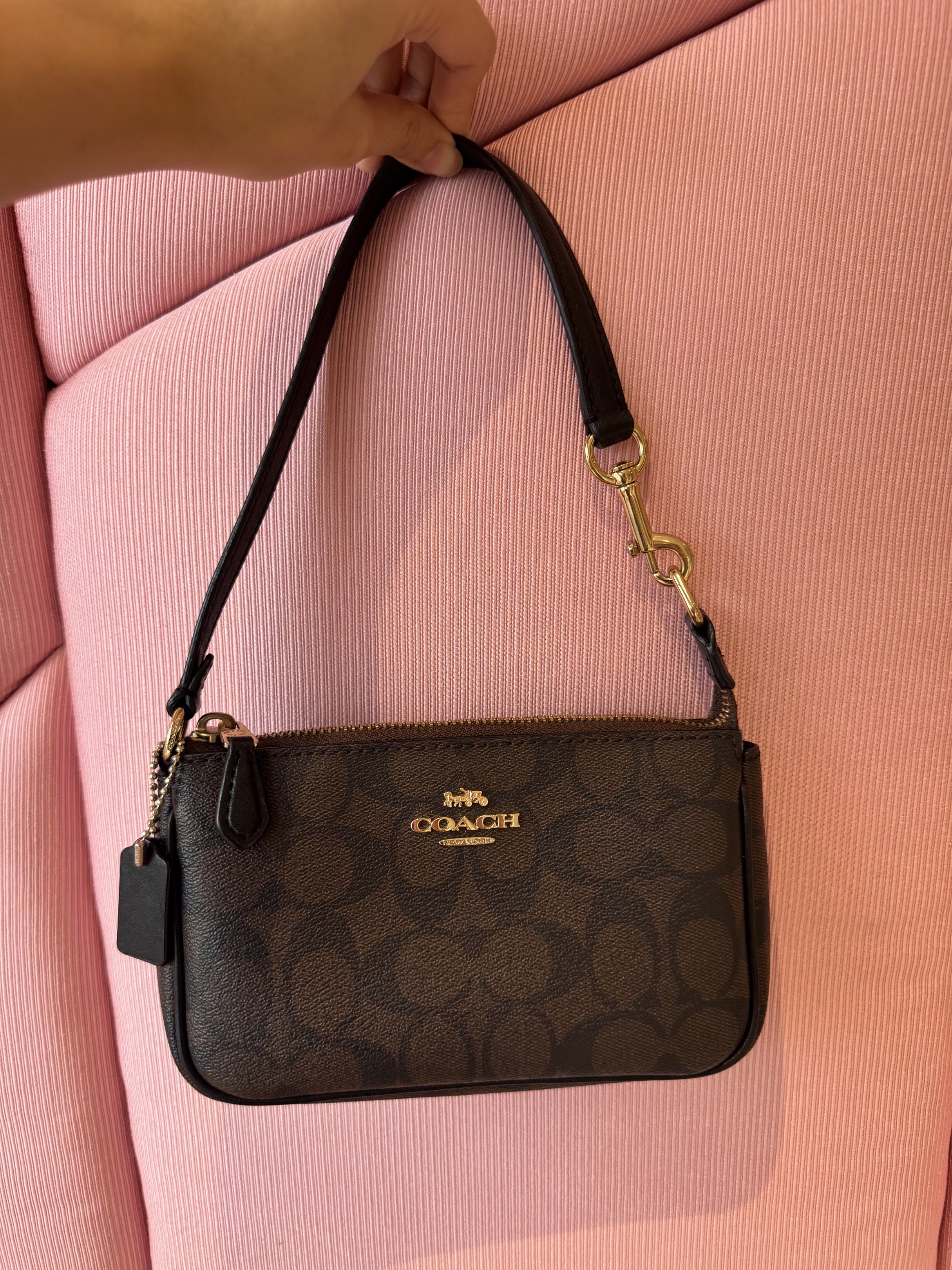 Coach Signature Wristlet (Category: Luxury Bags & Wallets) located in Cagayan de Oro. Submitted by declutteringszn (Listing ID 1418674400, Image 1). Description: - Authentic Coach wristlet - Signature brown Coach pattern - Top zipper closure - Detachable wrist strap - Gold-toned hardware - Compact design - Perfect for essentials.