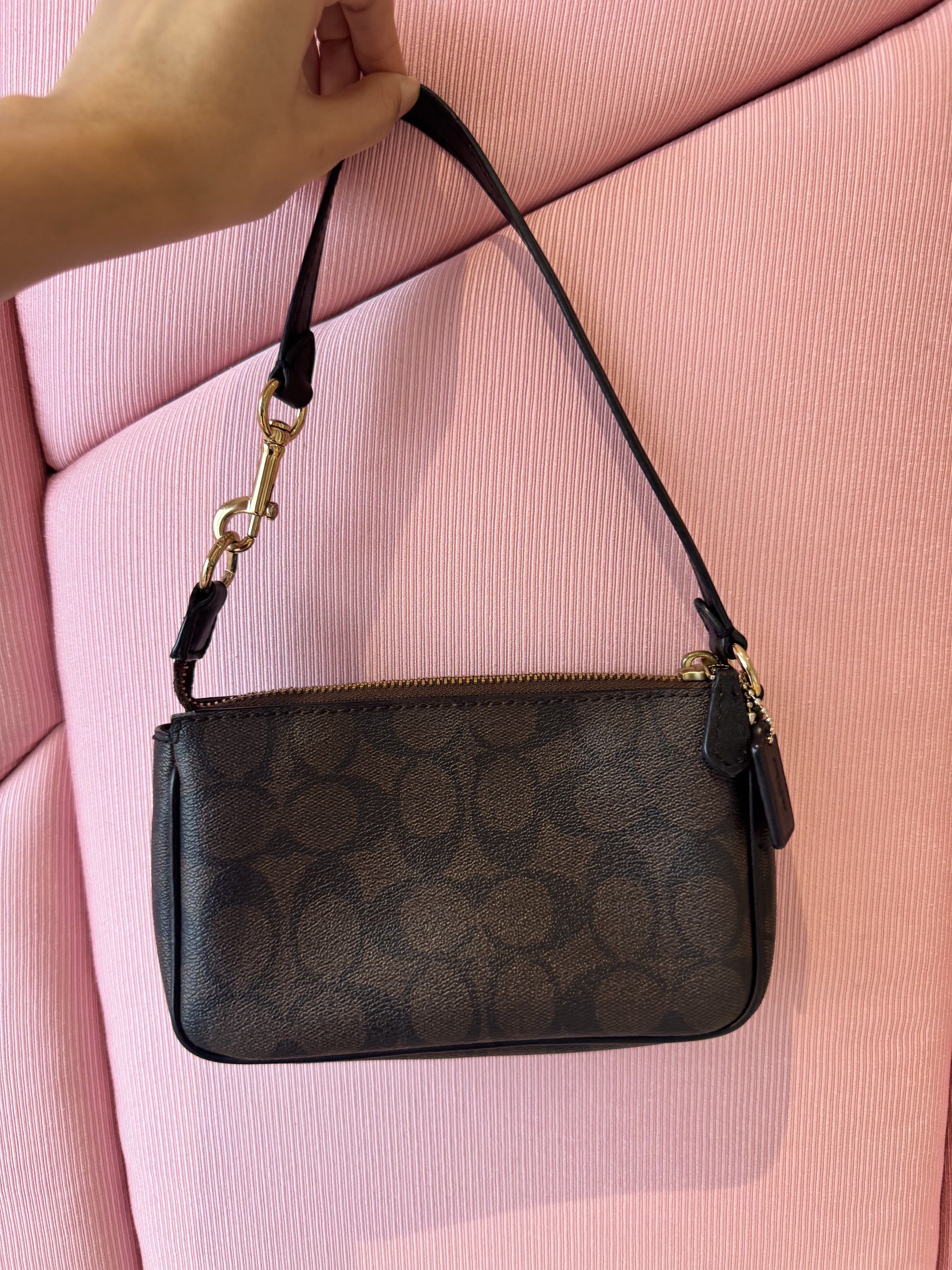 Coach Signature Wristlet (Category: Luxury Bags & Wallets) located in Cagayan de Oro. Submitted by declutteringszn (Listing ID 1418674400, Image 2). Description: - Authentic Coach wristlet - Signature brown Coach pattern - Top zipper closure - Detachable wrist strap - Gold-toned hardware - Compact design - Perfect for essentials.