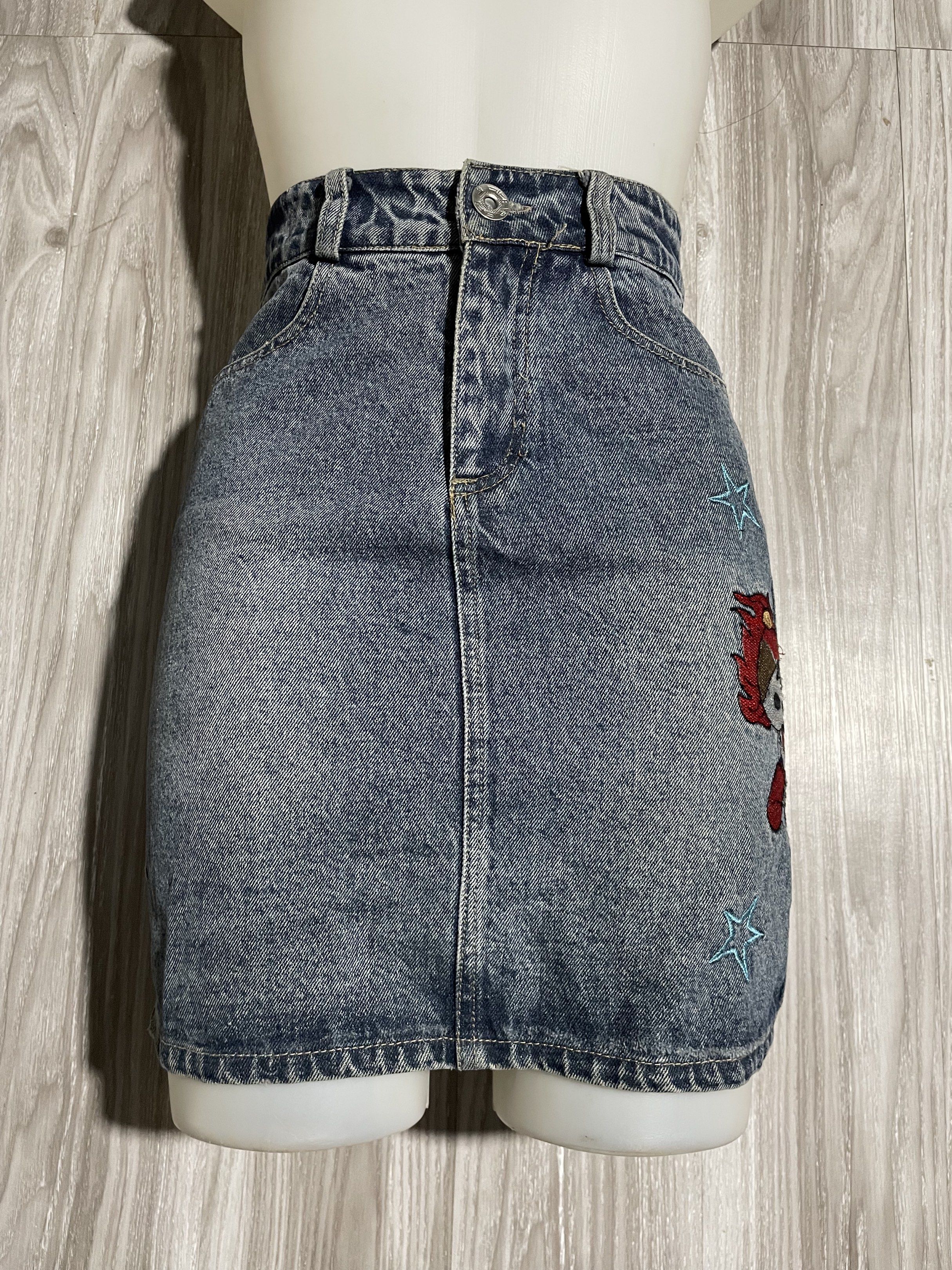 Denim Skirt with Patches (Category: Skirts) located in Caloocan City. Submitted by meng.collxn (Listing ID 1418694864, Image 3). Description: - Denim skirt with a classic wash - Straight cut design - Adorned with star and character patches - Includes two front and two back pockets - Button and zipper closure.
