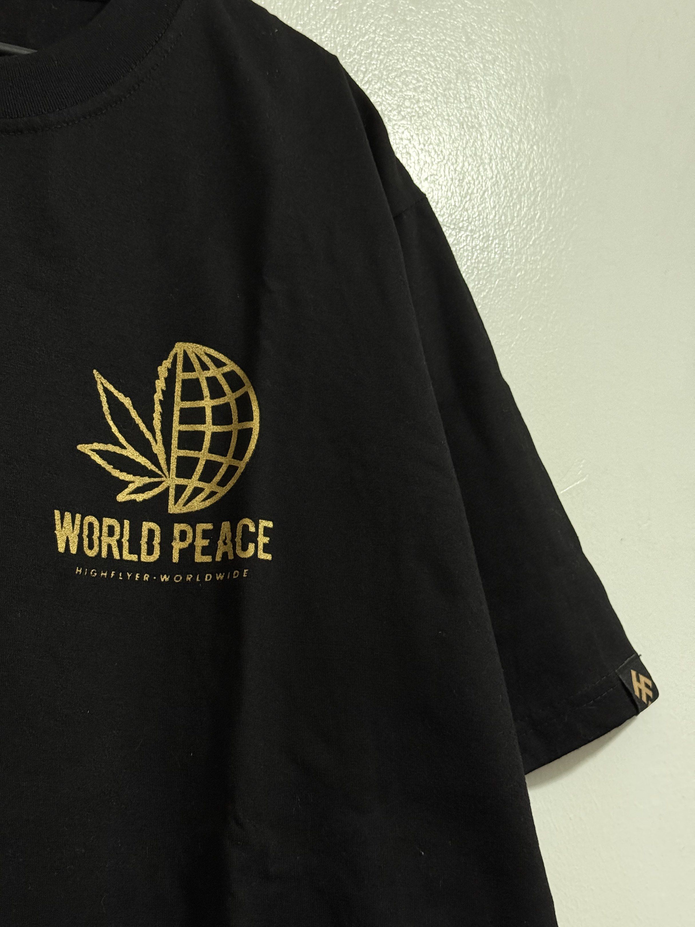 High Flyer World Peace T-shirt (Category: Tshirts & Polo Shirts ) located in Bulacan. Submitted by isnvl (Listing ID 1418768524, Image 2). Description: - Black High Flyer T-shirt - Gold "World Peace" design on front and back - XL size - Features cannabis leaf and globe graphic - High Flyer logo on sleeve and bottom.