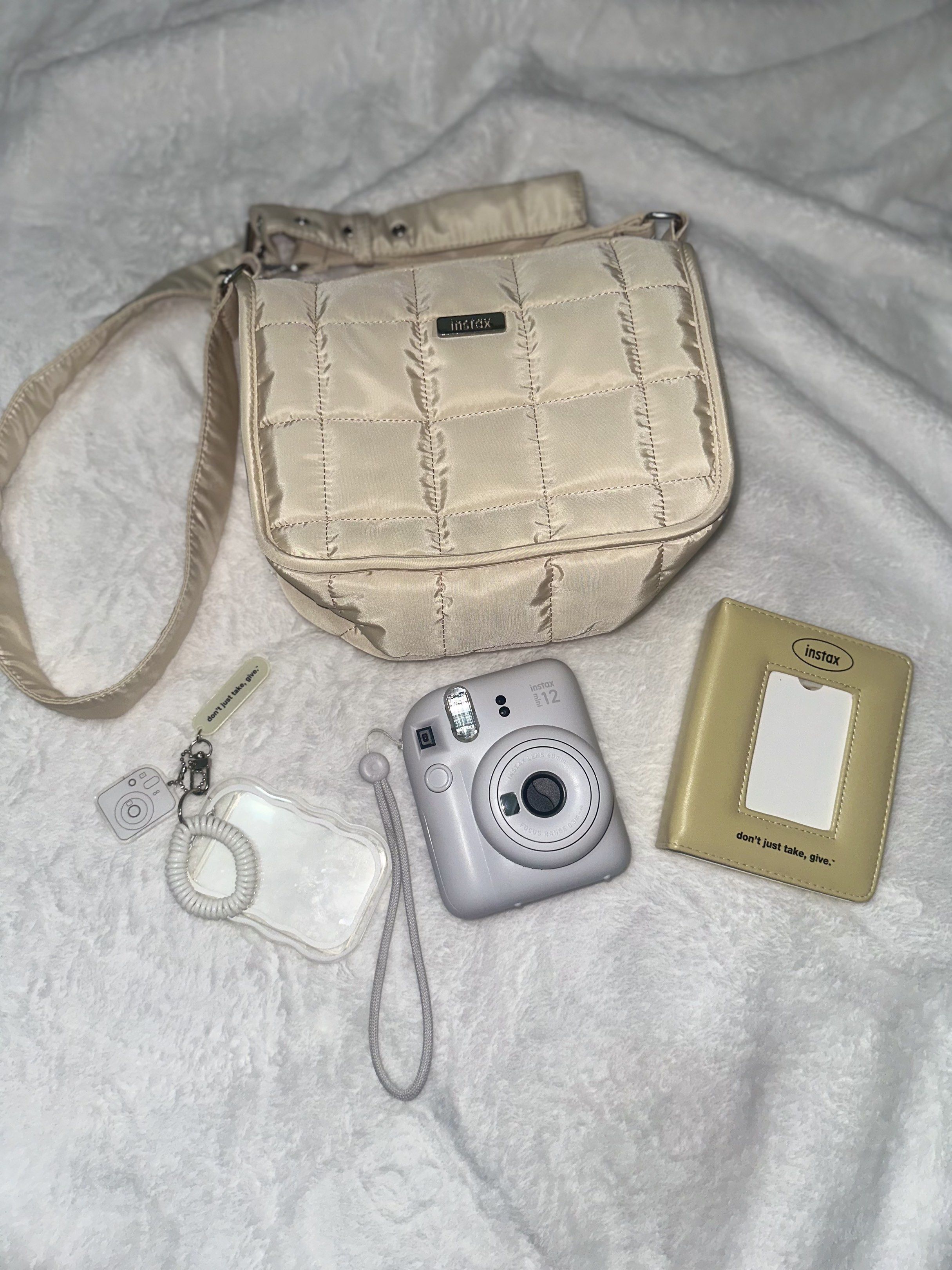 Instax Mini 12 Camera Bundle (Category: Cameras) located in Pasig City. Submitted by prelovedoftang (Listing ID 1418711048, Image 1). Description: - Instax Mini 12 Camera (Light Gray) - Beige Quilted Crossbody Bag - Beige Photo Frame with Clear Window - Keychain with Clear Holder.