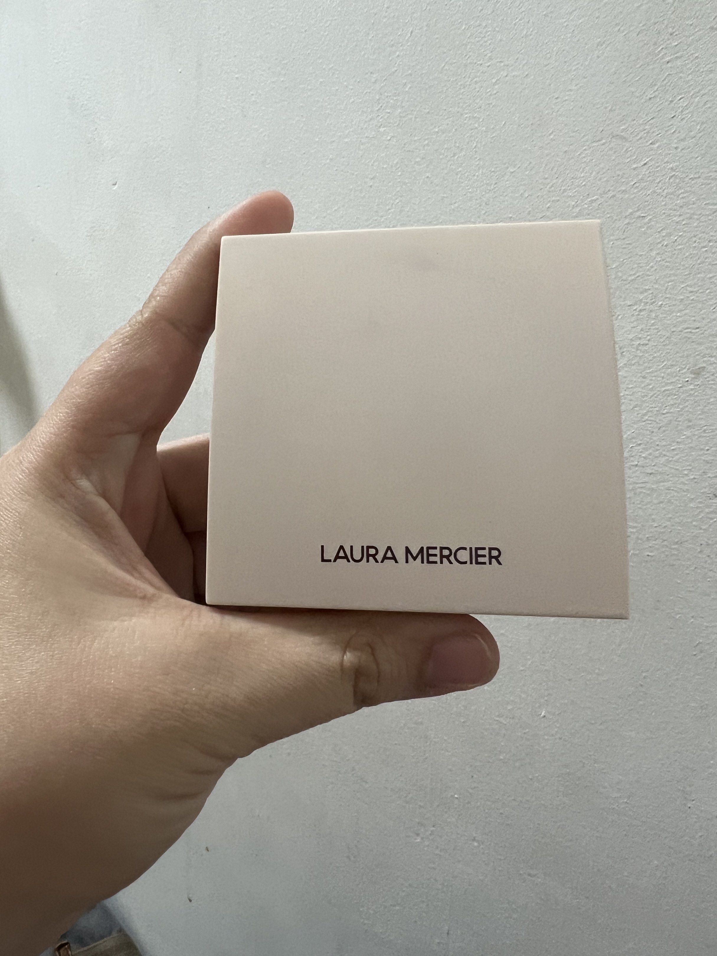 Laura Mercier Face Illuminator Powder (Category: Makeup) located in Pateros City. Submitted by j53221 (Listing ID 1418710574, Image 2). Description: - Laura Mercier Face Illuminator Powder - Light, shimmery shade - Square compact with light-colored casing - Pressed powder - Brand name printed on the back.