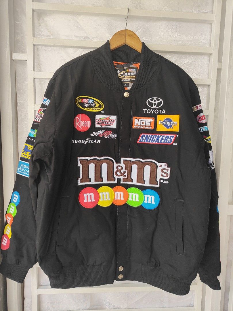 M&M's NASCAR Racing Jacket (Category: Coats, Jackets and Outerwear) located in Pandi. Submitted by yanyan_apparel.store08 (Listing ID 1418629569, Image 1). Description: - Black racing jacket - Features sponsor patches: M&M's, Toyota, Snickers - Large M&M's character on the back - "kylebusch.com" printed on the back - Bomber jacket style - Ribbed collar and cuffs - Button-up front closure brand new onhand medium large xl full embroid .