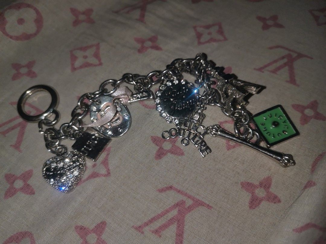 Silver Juicy Couture Bracelet (Category: Charms) located in Manila. Submitted by krishneveragain (Listing ID 1418706238, Image 1). Description: - Silver keychain - Features heart, horseshoe, and green square charms - Includes a key ring - Charms connected by a chain - Made of metal.