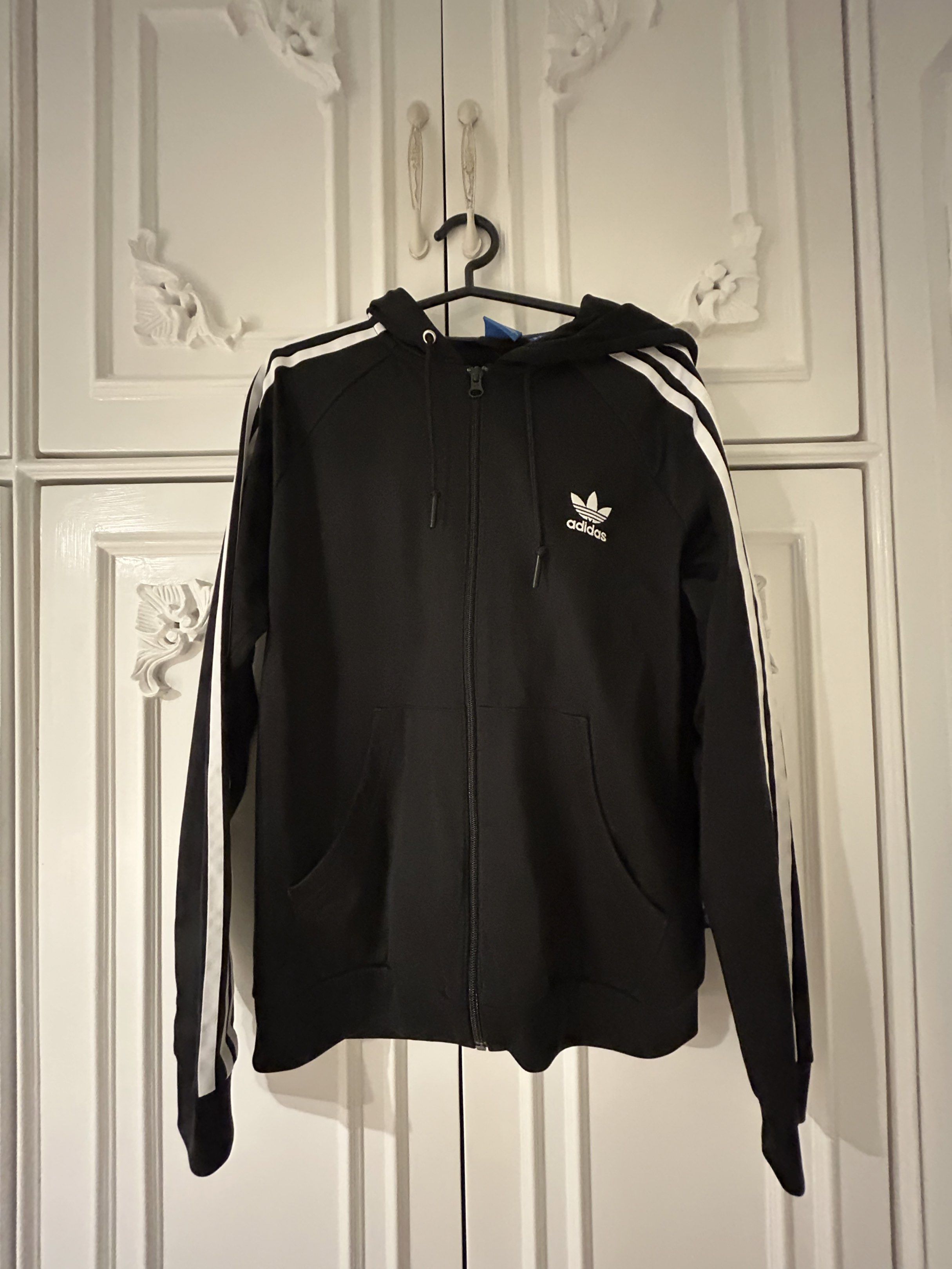 Adidas Black Hoodie Jacket Three Stripes (Category: Coats, Jackets and Outerwear) located in Calamba. Submitted by baskybears (Listing ID 1418923663, Image 1). Description: - Adidas hoodie jacket - Black with white stripes on sleeves - Full zip closure - Hooded.