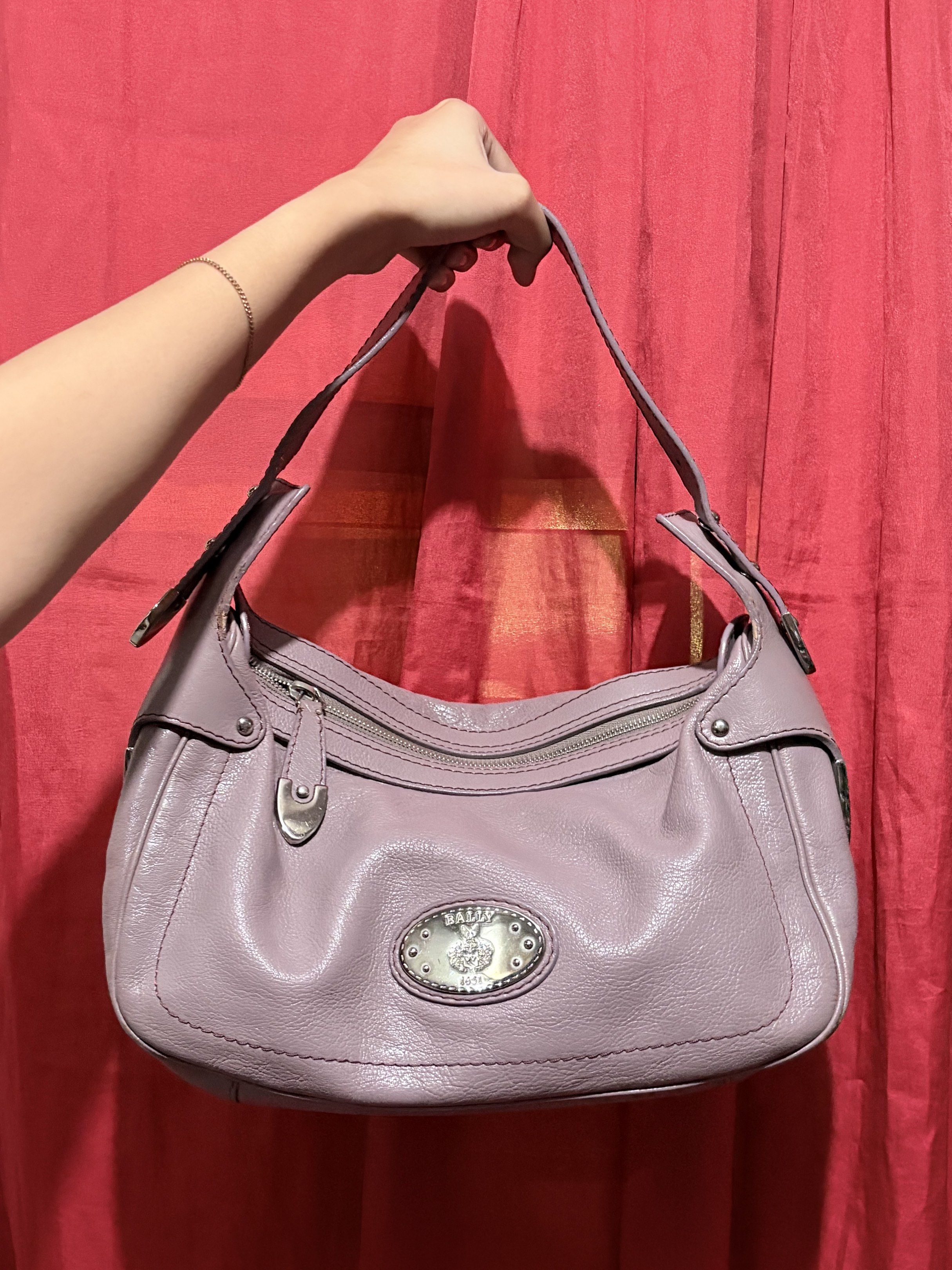 Bally Shoulder Bag (Category: Luxury Bags & Wallets) located in Manila. Submitted by cufflej (Listing ID 1418956936, Image 1). Description: - Lavender Bally shoulder bag - Top zipper closure - Single shoulder strap - Silver-tone logo - Brown fabric lining - Silver-tone Bally metal tag - Curved shape - Leather exterior.
