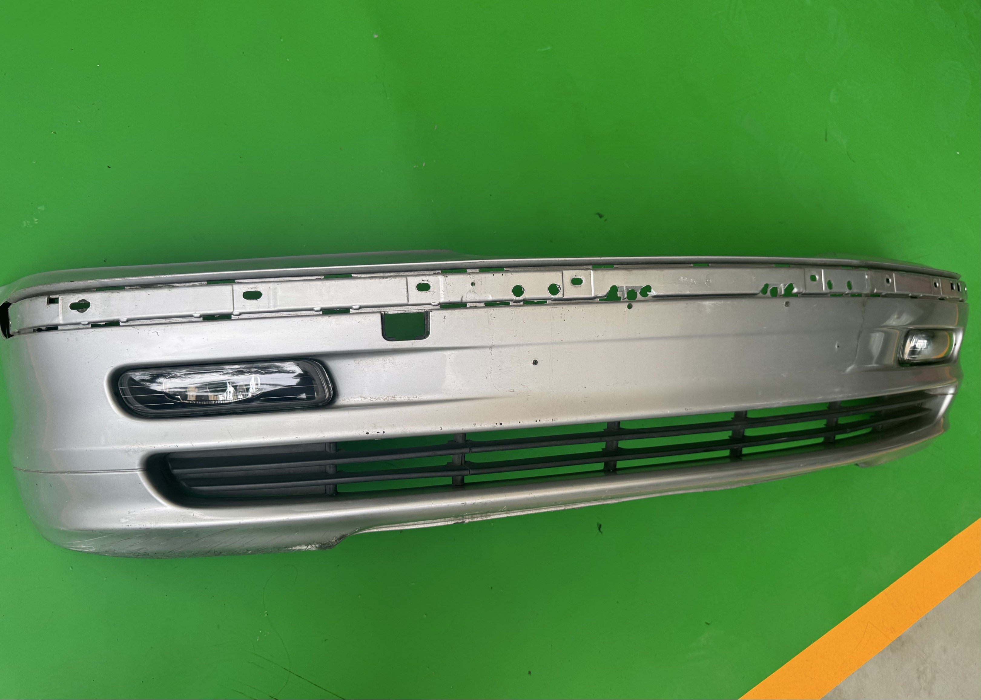 BMW E46 Prefacelift Silver Car Bumper with Fog Lights (Category: Body Parts and Accessories) located in Pasig City. Submitted by mp39393 (Listing ID 1418859659, Image 3). Description: - Silver car bumper with fog lights - Includes lower grille and mounting points - Designed for a specific car model, pre facelift E46 - Functional, despite some wear and tear.