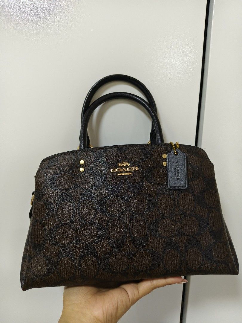 Coach mini lillie (Category: Luxury Bags & Wallets) located in Rizal. Submitted by ortegaalex06291 (Listing ID 1418908841, Image 1). Description: - Coach satchel handbag - Brown signature print - Top handle and detachable shoulder strap - Zip closure - Gold-tone hardware - Includes Coach hangtag - Black interior - Structured shape - Classic design.