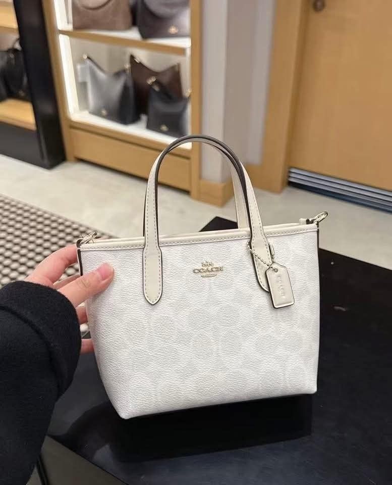Coach Mini Tote Bag (Category: Luxury Bags & Wallets) located in Quezon City. Submitted by k2collection.mnl (Listing ID 1418956303, Image 2). Description: - Coach Mini Tote Bag - Top handle and detachable shoulder strap - Features the iconic Coach logo - Available in brown, white, beige, and pink - Secure zip closure - Elegant gold-tone hardware.