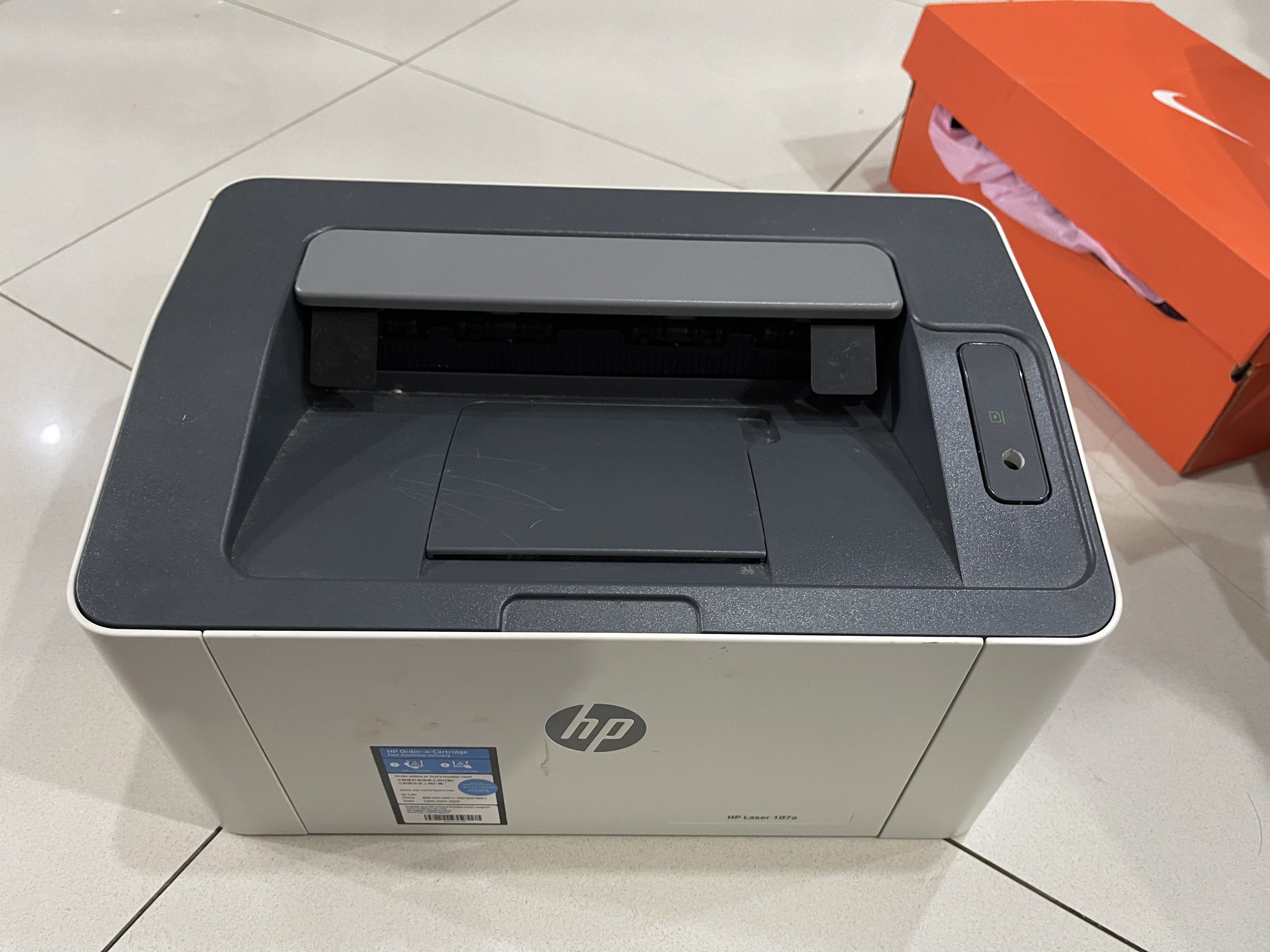 HP Laser 107a Printer (Category: Printers, Scanners & Copiers) located in Taguig. Submitted by i.am.johan (Listing ID 1418909986, Image 3). Description: - HP Laser 107a printer - Color: White and gray - Features the HP logo - Model number clearly visible - Manufactured in April 2019 - Includes power button - Has a paper output tray.