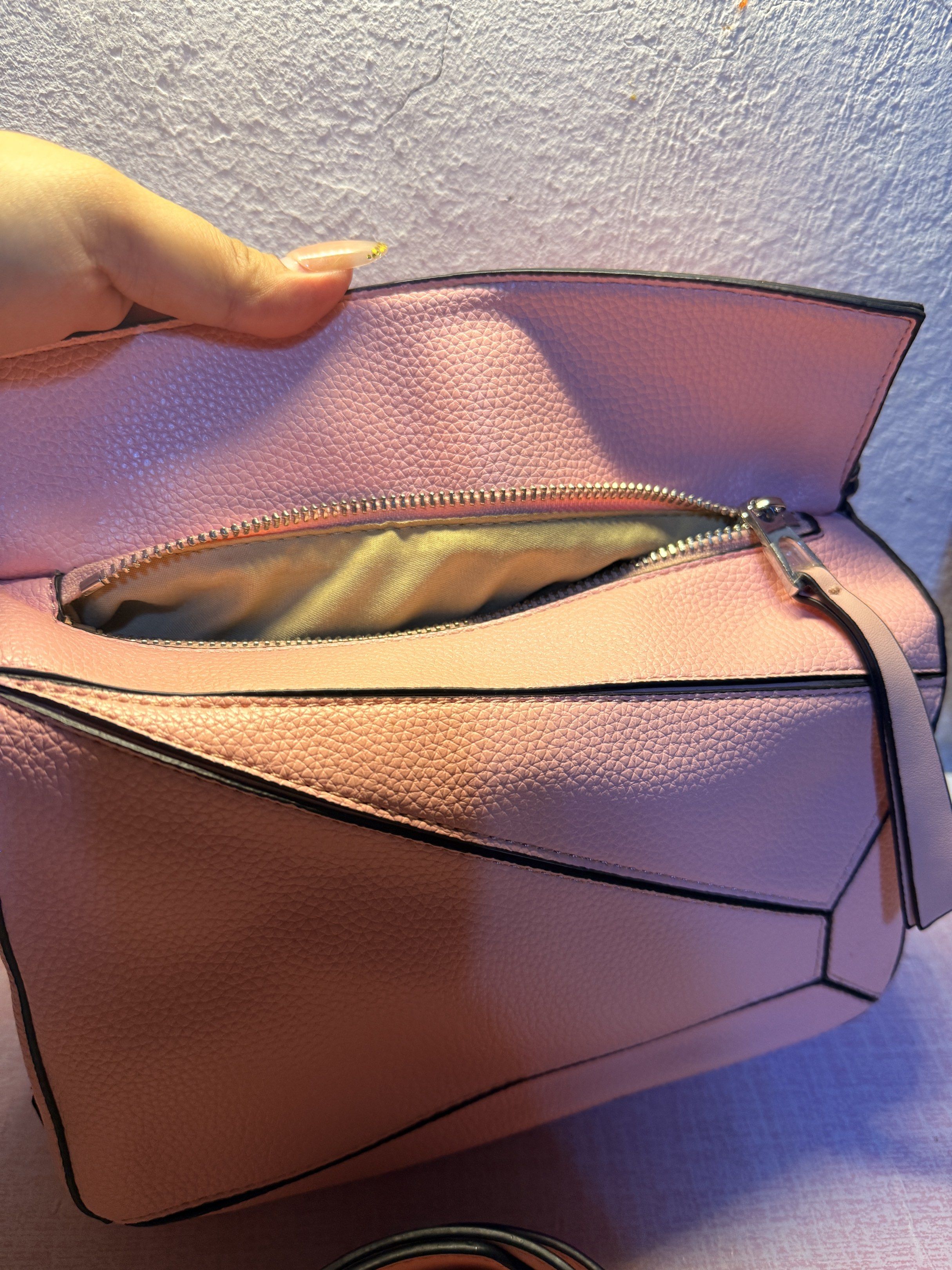 Loewe Puzzle Bag - Pink (Category: Luxury Bags & Wallets) located in Manila. Submitted by ninaleechiu (Listing ID 1418900597, Image 3). Description: - Loewe Puzzle Bag - Color: Pink - Detachable shoulder strap - Zip closure - Textured leather exterior - Geometric design with black trim - Embossed Loewe logo - Top handle - Spacious interior.