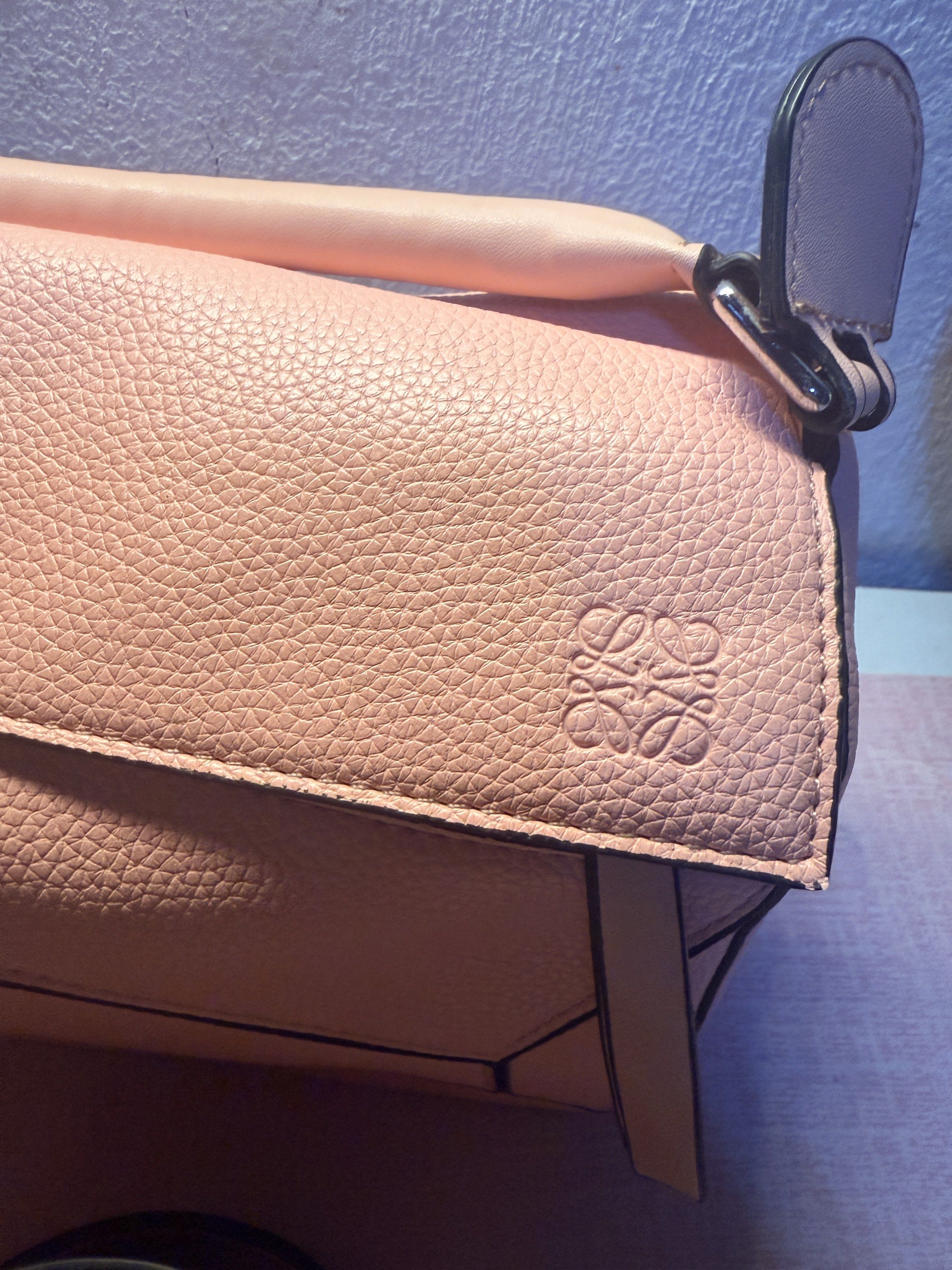 Loewe Puzzle Bag - Pink (Category: Luxury Bags & Wallets) located in Manila. Submitted by ninaleechiu (Listing ID 1418900597, Image 2). Description: - Loewe Puzzle Bag - Color: Pink - Detachable shoulder strap - Zip closure - Textured leather exterior - Geometric design with black trim - Embossed Loewe logo - Top handle - Spacious interior.