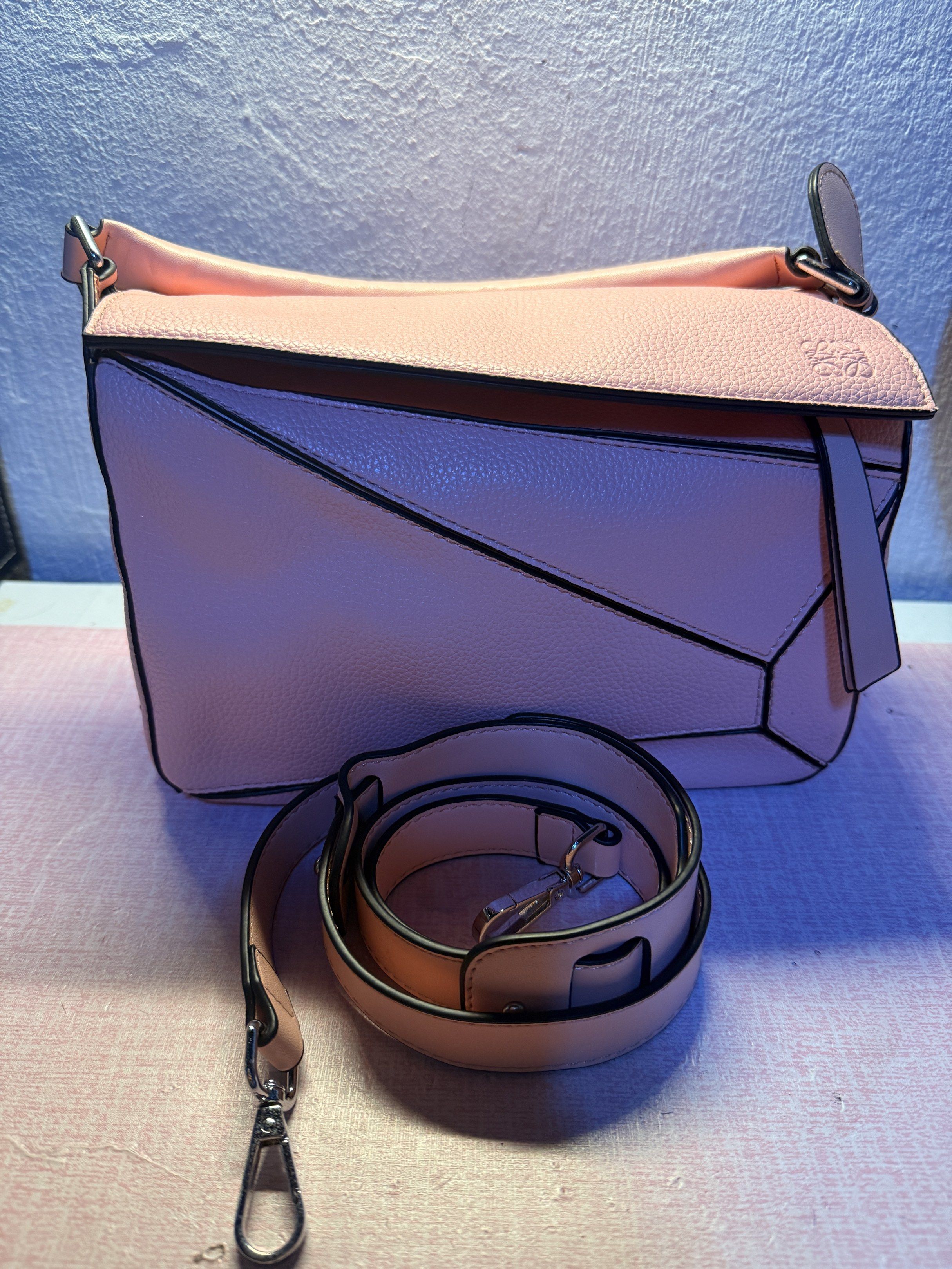 Loewe Puzzle Bag - Pink (Category: Luxury Bags & Wallets) located in Manila. Submitted by ninaleechiu (Listing ID 1418900597, Image 1). Description: - Loewe Puzzle Bag - Color: Pink - Detachable shoulder strap - Zip closure - Textured leather exterior - Geometric design with black trim - Embossed Loewe logo - Top handle - Spacious interior.
