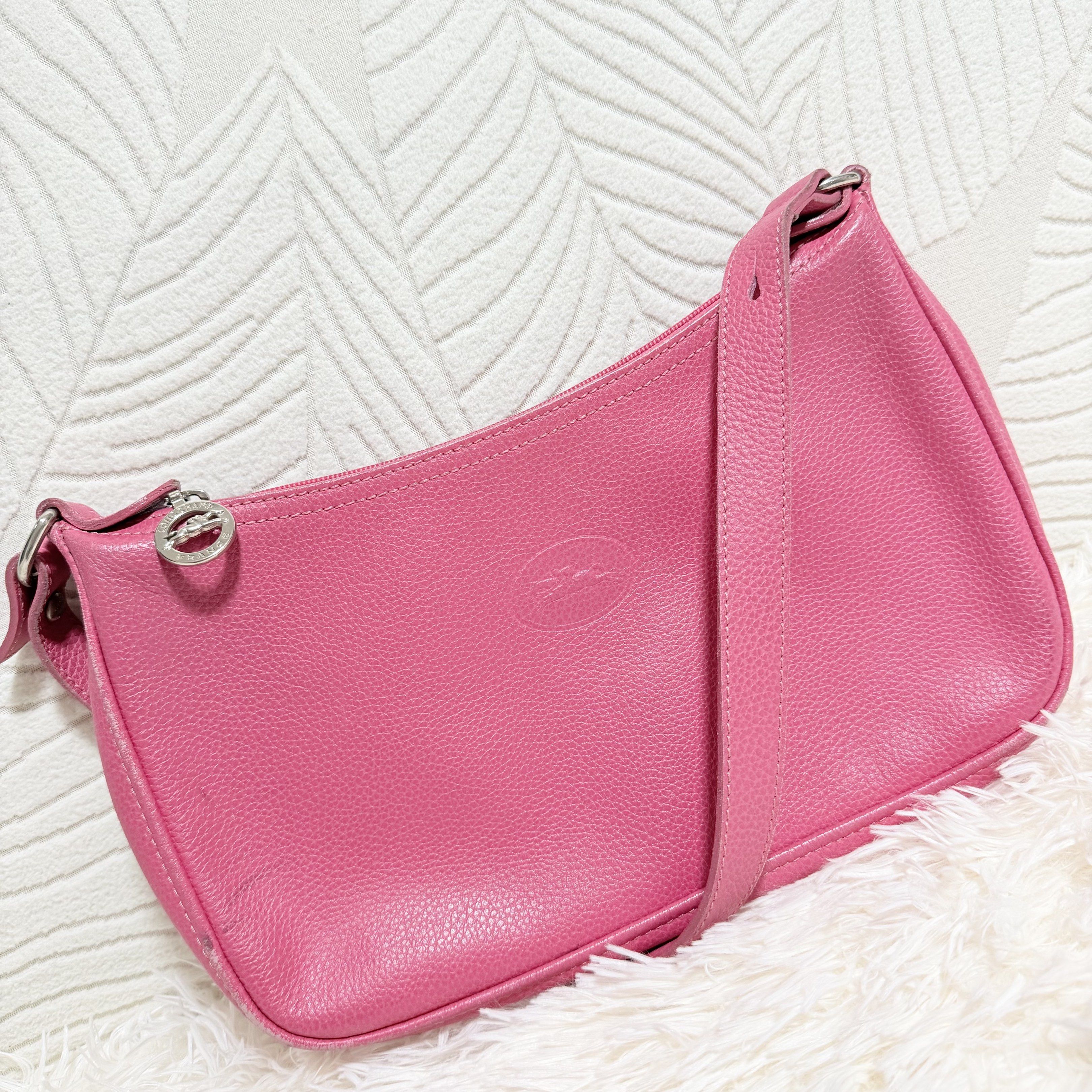 Longchamp Le Pliage Cuir Shoulder Bag (Category: Luxury Bags & Wallets) located in Pasig City. Submitted by trendapparelph (Listing ID 1418849646, Image 2). Description: - Authentic Longchamp Le Pliage Cuir shoulder bag - Vibrant pink color - Made of genuine leather - Features a zip closure - Includes a shoulder strap - Interior pocket - Made in France - Iconic Longchamp logo details.