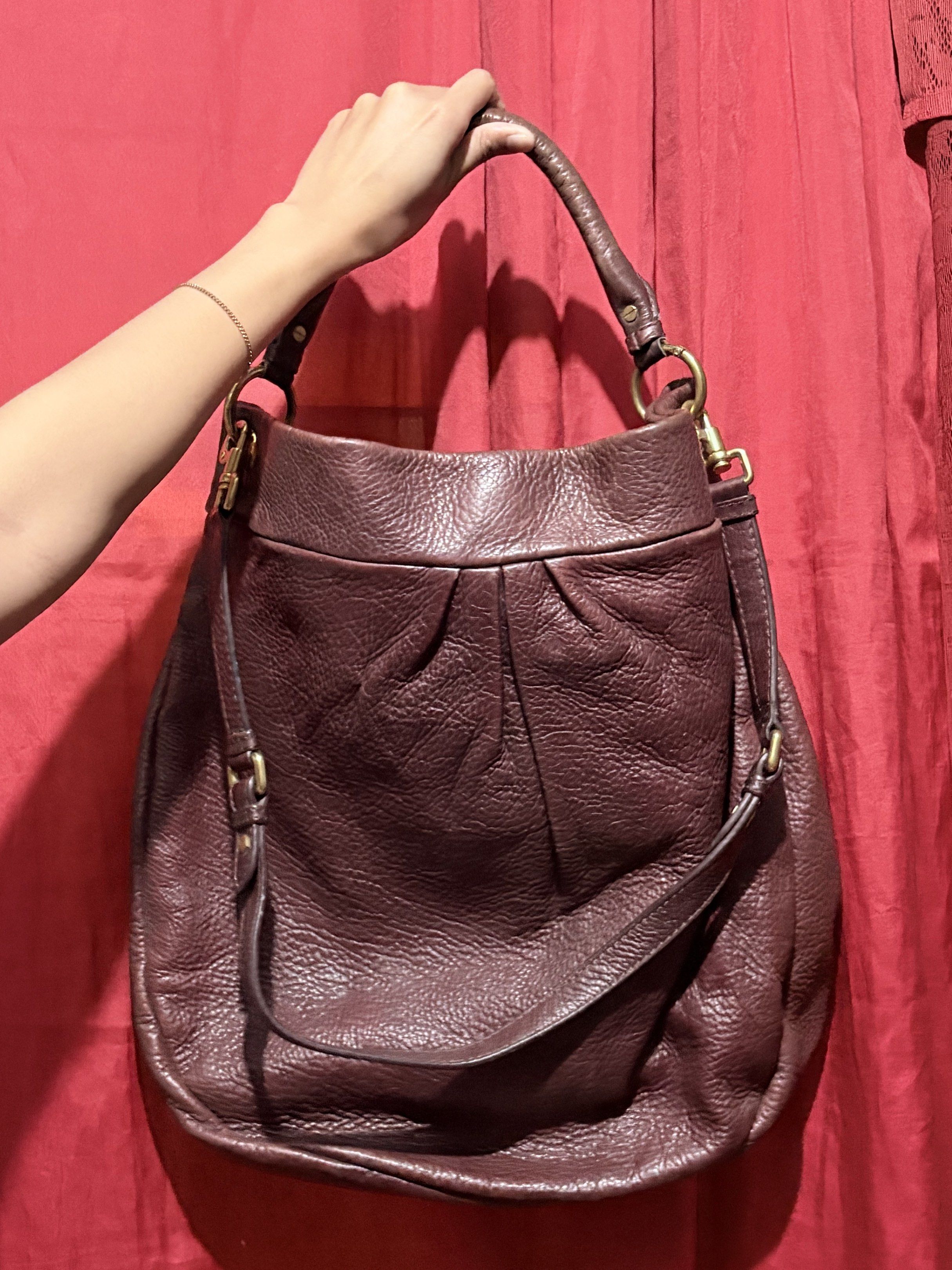 Marc Jacobs Leather Hobo Bag (Category: Luxury Bags & Wallets) located in Manila. Submitted by cufflej (Listing ID 1418958042, Image 2). Description: - Authentic Marc Jacobs hobo bag - Rich burgundy color - Made of high-quality leather - Top handle and detachable shoulder strap - Interior lined with Marc Jacobs logo - Includes small metal brand plate.