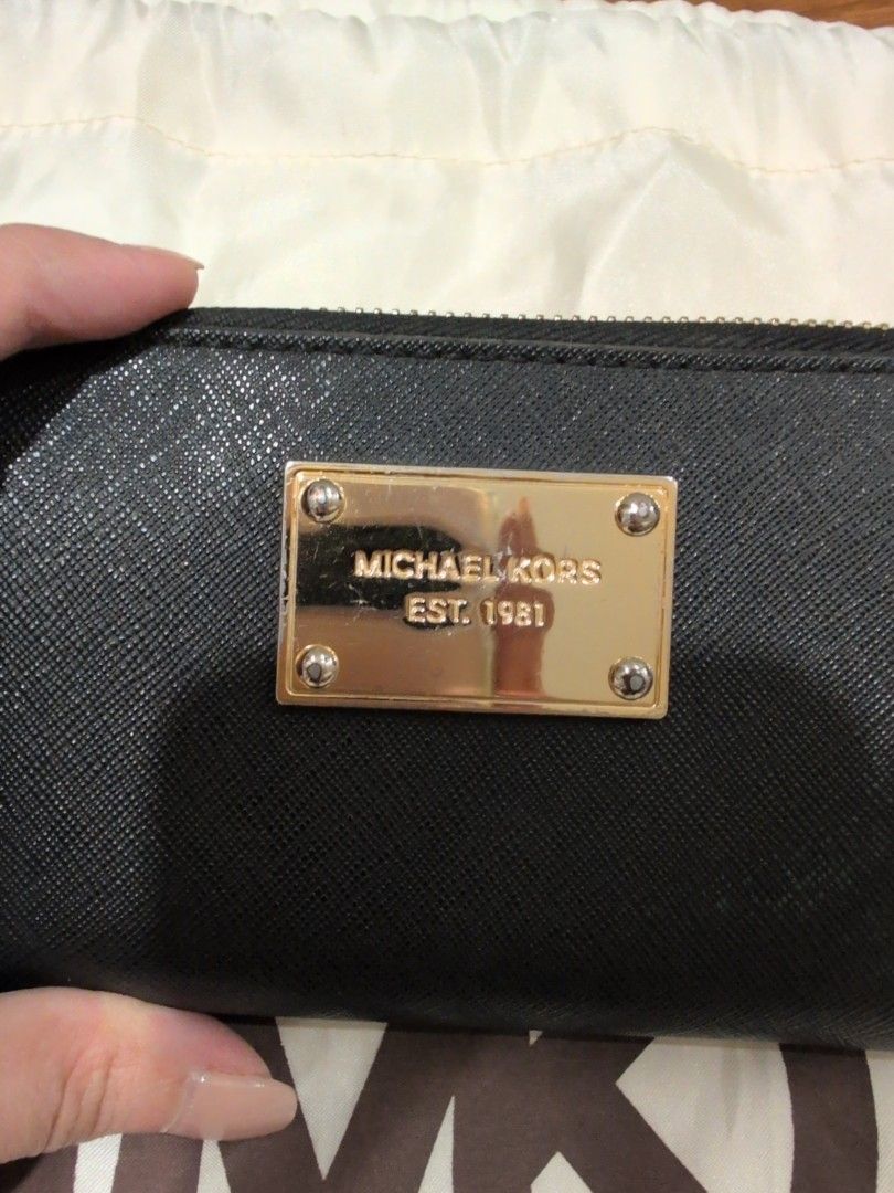 Michael Kors Black Zip Around Wallet (Category: Wallets & Card holders) located in Manila. Submitted by csisters3 (Listing ID 1418890269, Image 2). Description: - Michael Kors black zip-around wallet - Gold-tone metal plate with "Michael Kors 1981" - Multiple card slots and compartments - Includes a wrist strap - Gold-toned zipper and hardware bought in 2013 leather still in good condition .