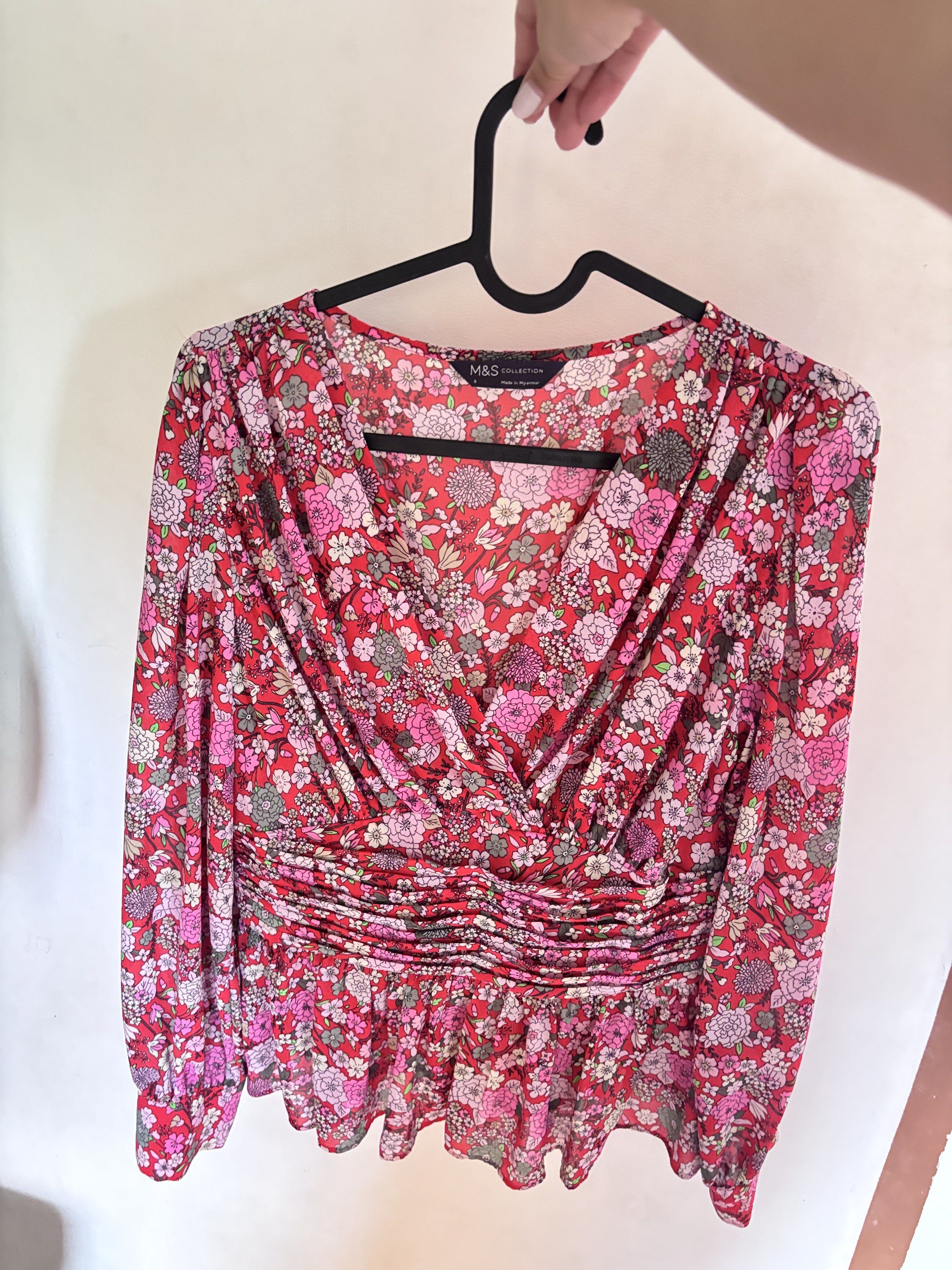 M&S Floral Blouse (Category: Blouses) located in Meycauayan. Submitted by declutter0403 (Listing ID 1418816634, Image 1). Description: - M&S floral blouse - Features a vibrant print in red, pink, and white - Design: V-neckline and long sleeves - Details: Gathered waist and peplum hem - Made in Myanmar.